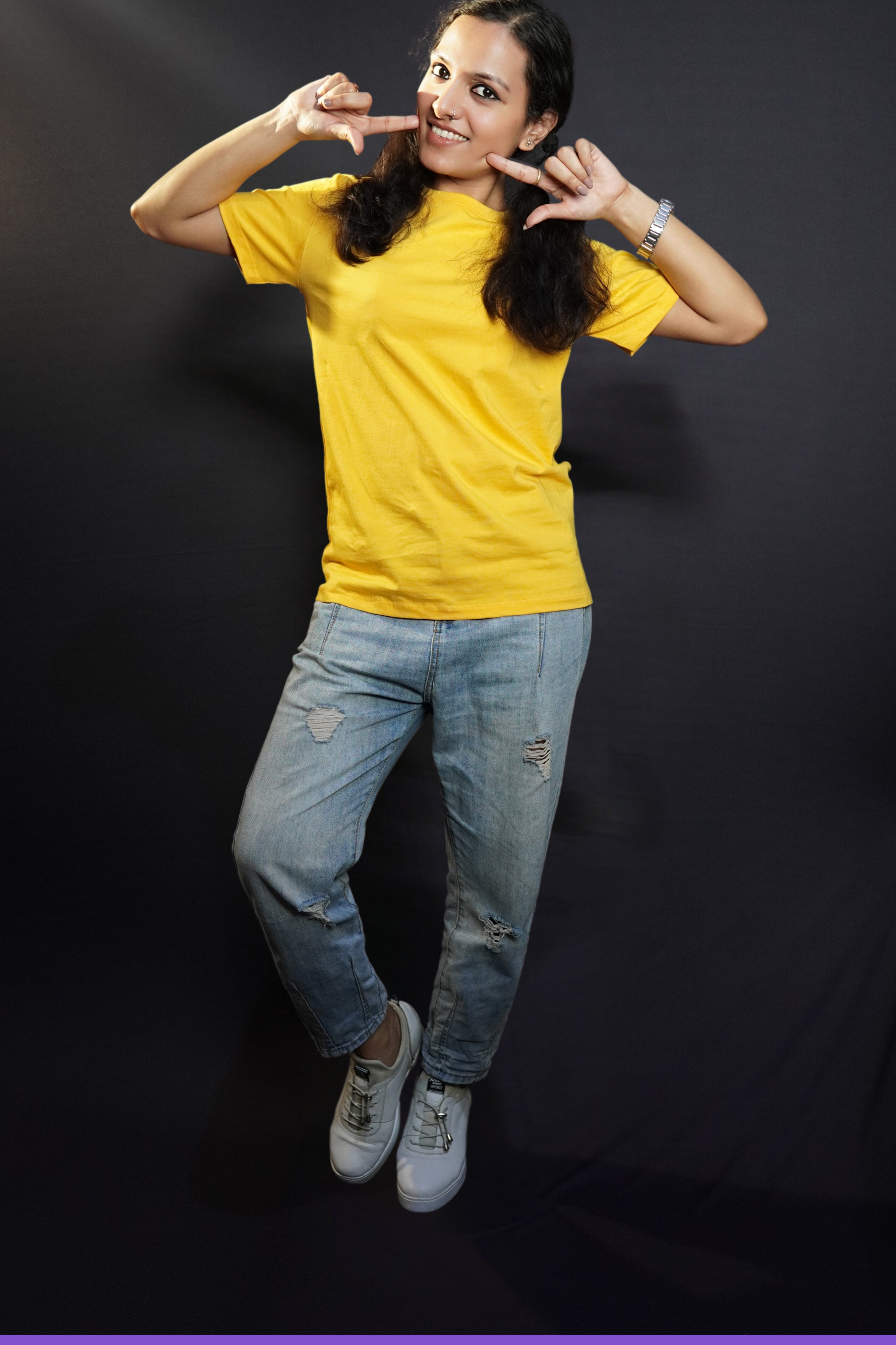 A stylish model wearing short sleeved comfortable cotton T shirt paired with blue jeans posing against a dark background-Muselot
