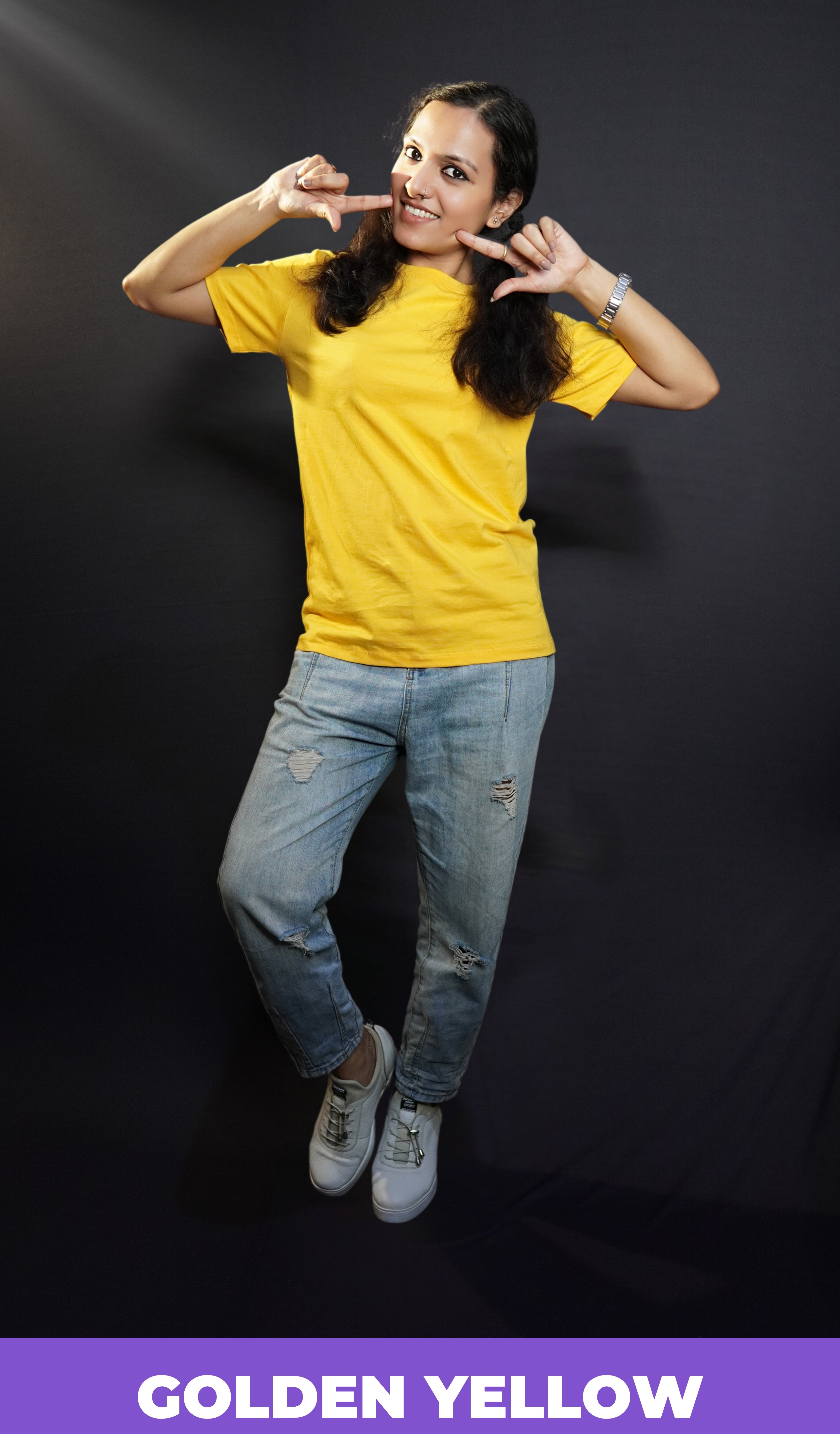 A stylish model wearing short sleeved comfortable cotton T shirt paired with blue jeans posing against a dark background-Muselot