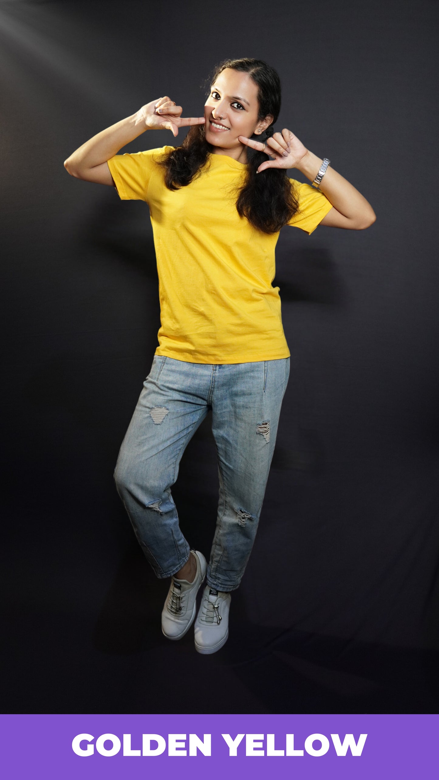 A stylish model wearing short sleeved comfortable cotton T shirt paired with blue jeans posing against a dark background-Muselot