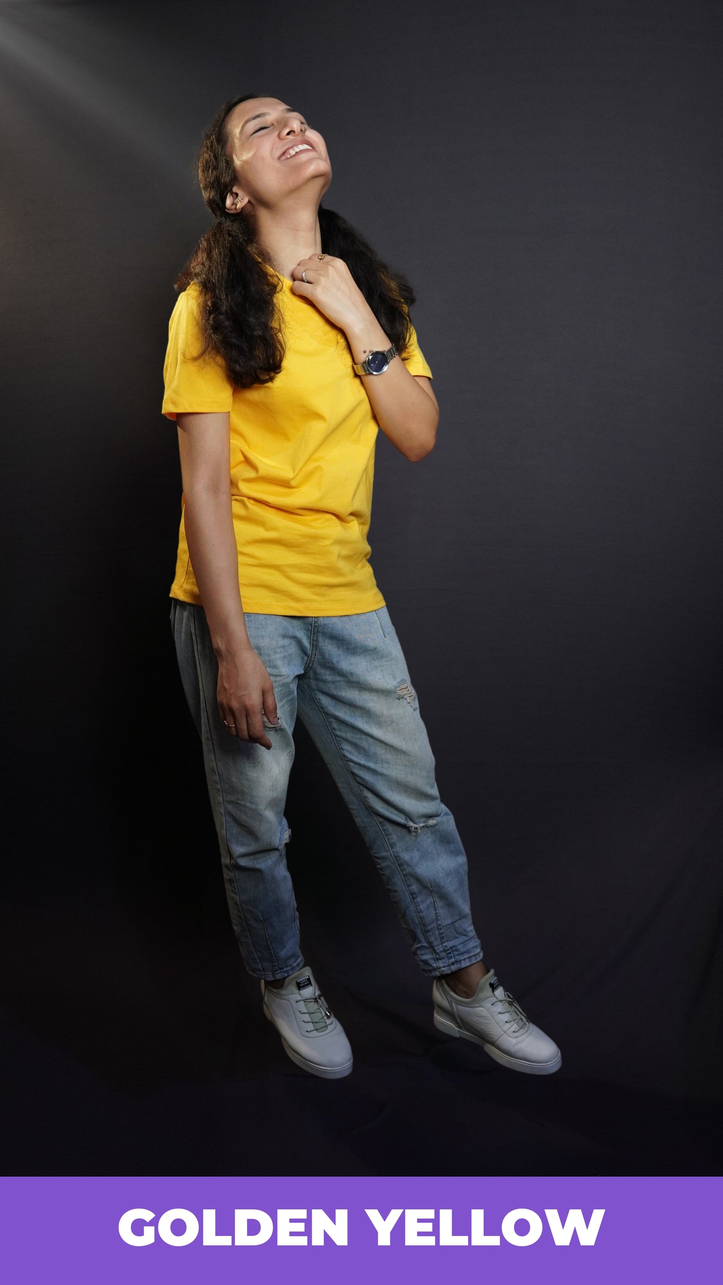 A happy woman in a casual cotton round neck short sleeved golden yellow plain T shirt paired with blue jeans and comfortable shoes-Muselot