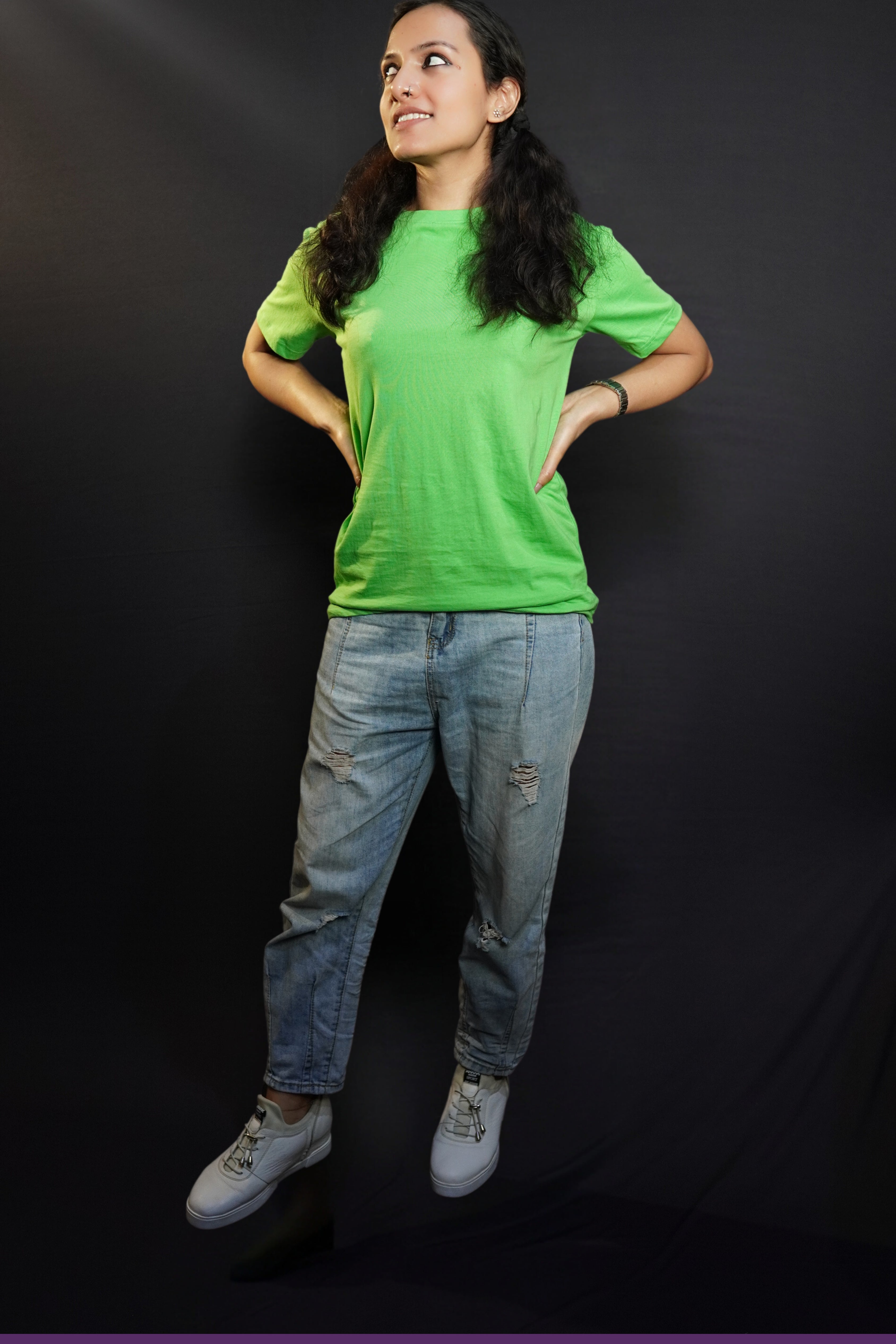 A stylish model posing with her hands on her sides looking sideways, wearing a lime green cotton long length adult's t-shirt, highlighting a trendy snug fit-Muselot