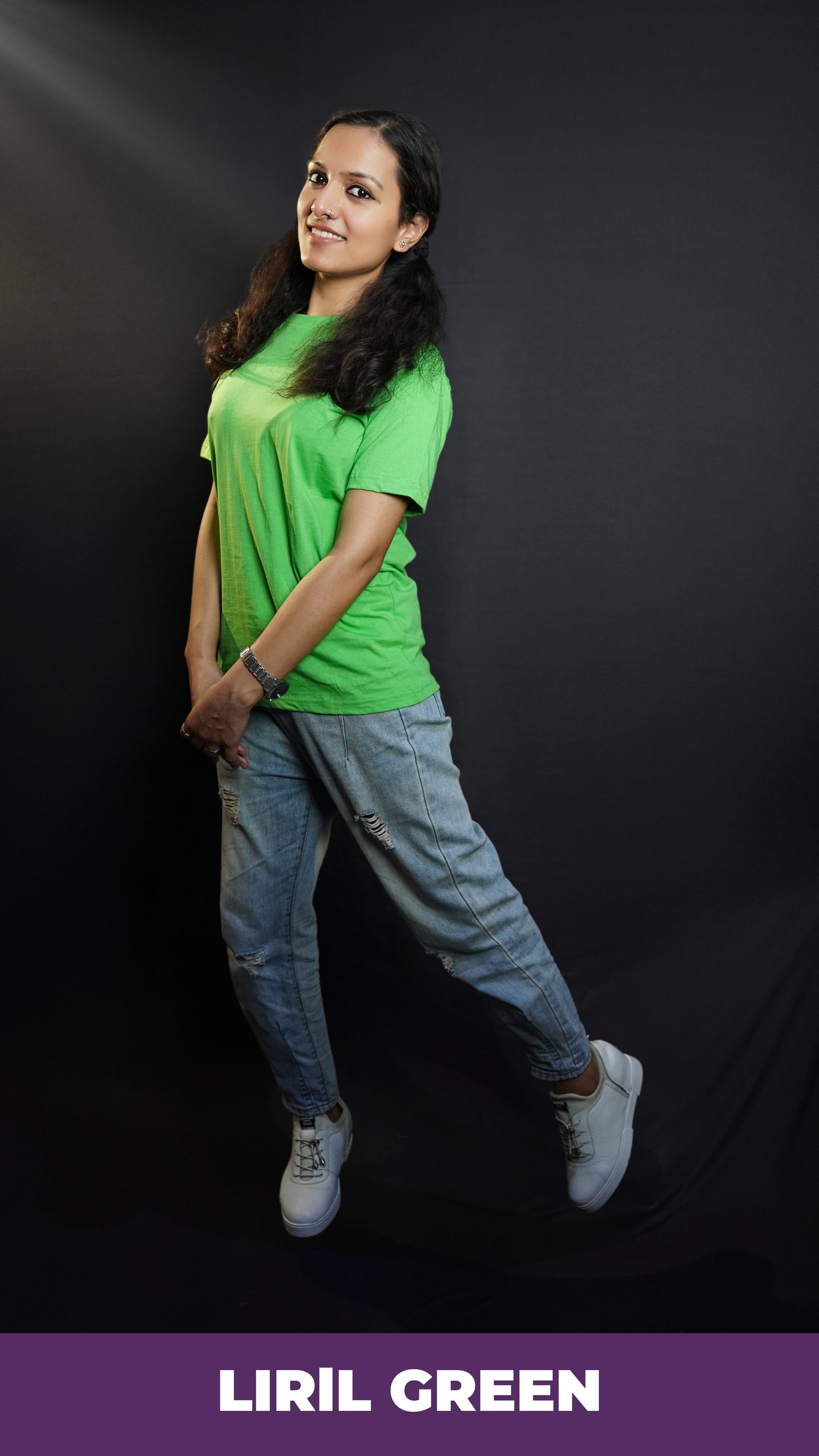 A smiling woman wearing a plus size lime green plain t-shirt with short sleeves and round neck, standing sideways as she sways slightly with her hands grabbing each other, showcasing a fashionable baggy fit-Muselot