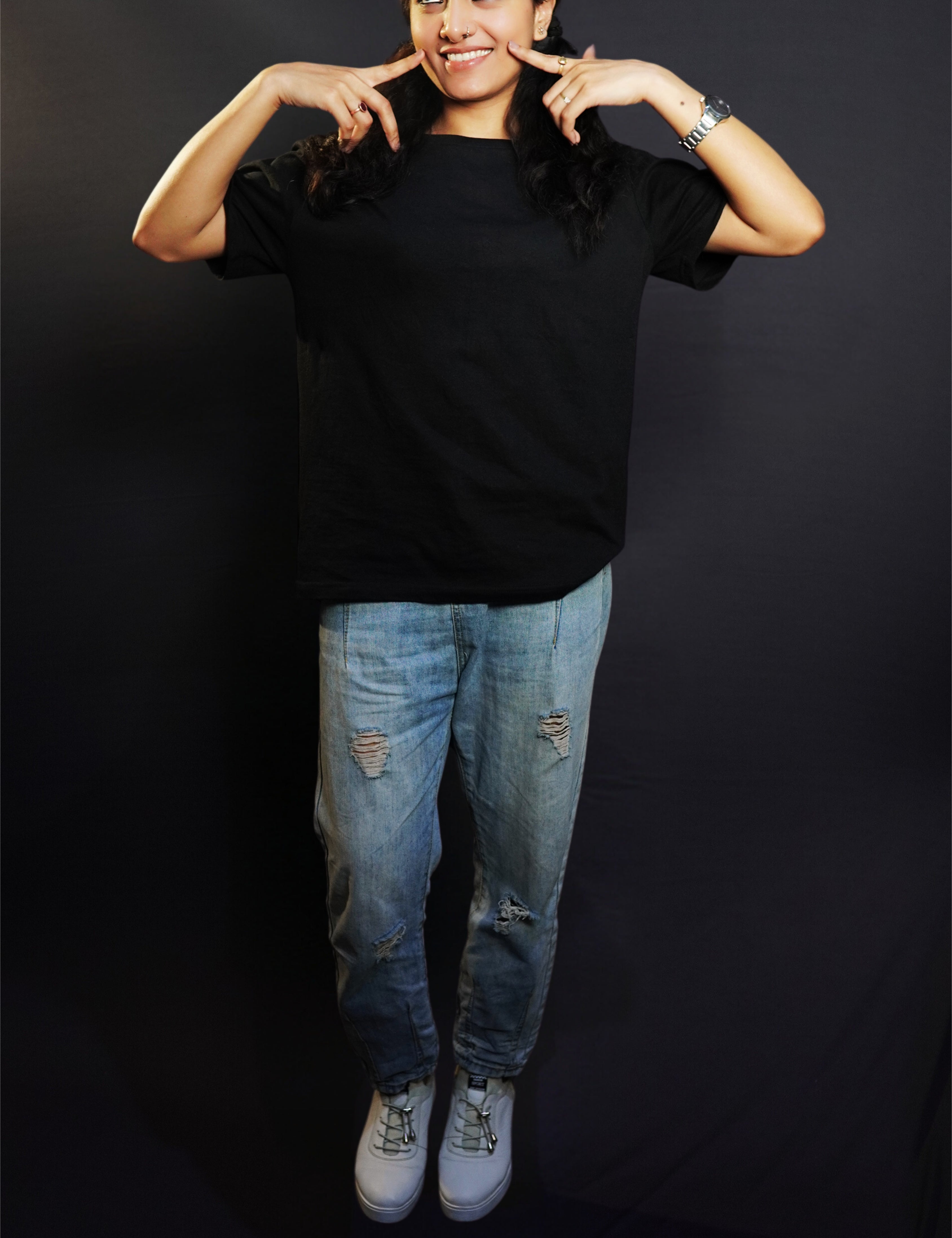 A happy woman posing with her fingers on her cheeks smiling brightly, wearing a unisex plain midnight black round neck t-shirt, showcasing a cute casual fit-Muselot