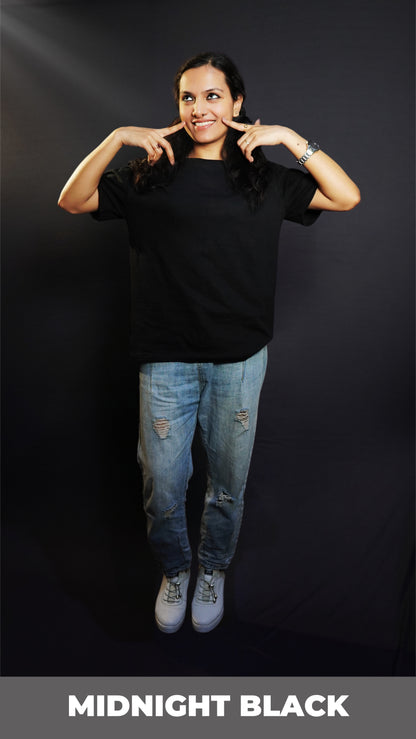 A happy woman posing with her fingers on her cheeks smiling brightly, wearing a unisex plain midnight black round neck t-shirt, showcasing a cute casual fit-Muselot