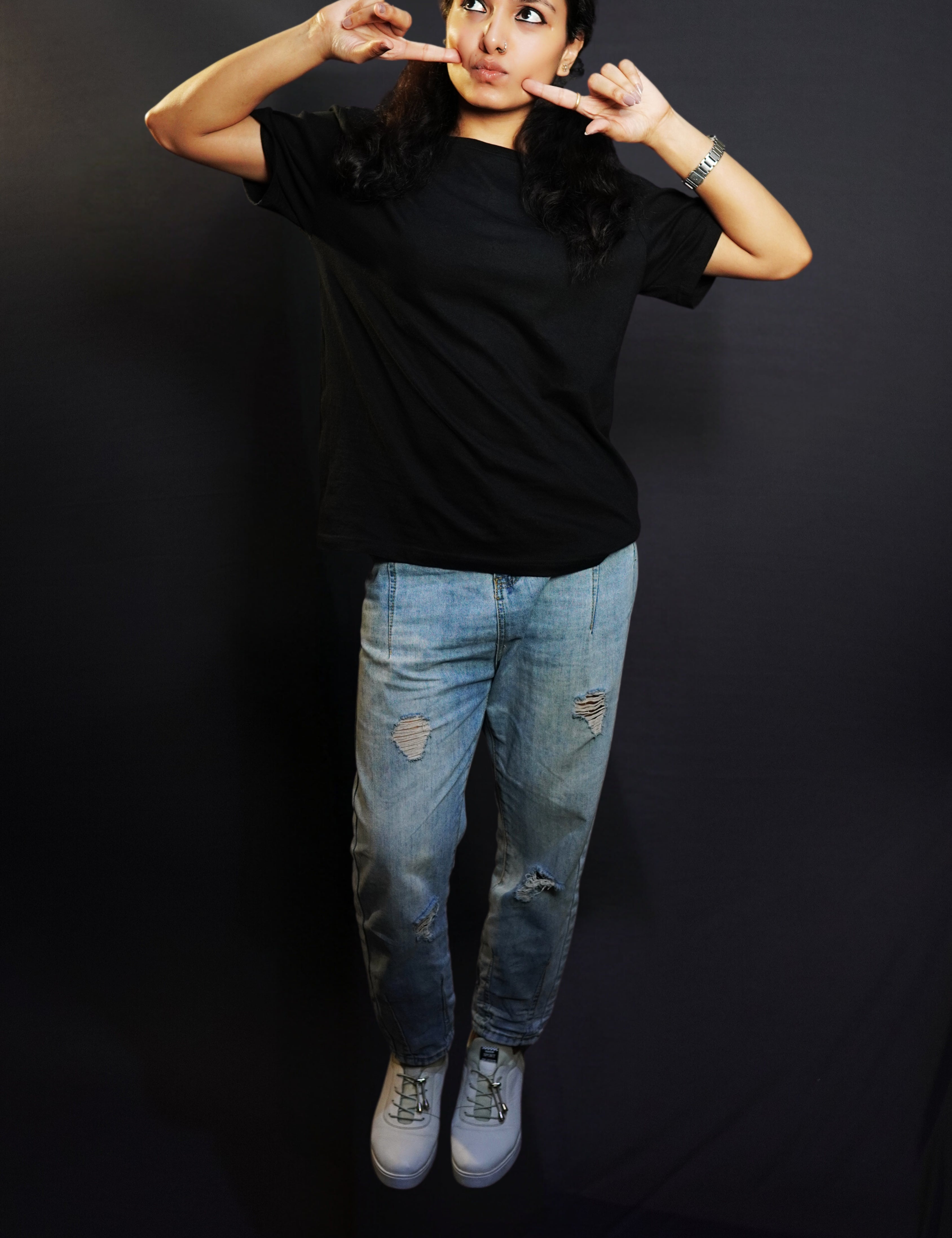A woman in a plain adult's midnight black t-shirt with round neck, short sleeves and long length, posing with her fingers poking her cheeks, pouting a little, highlighting a cute informal look-Muselot