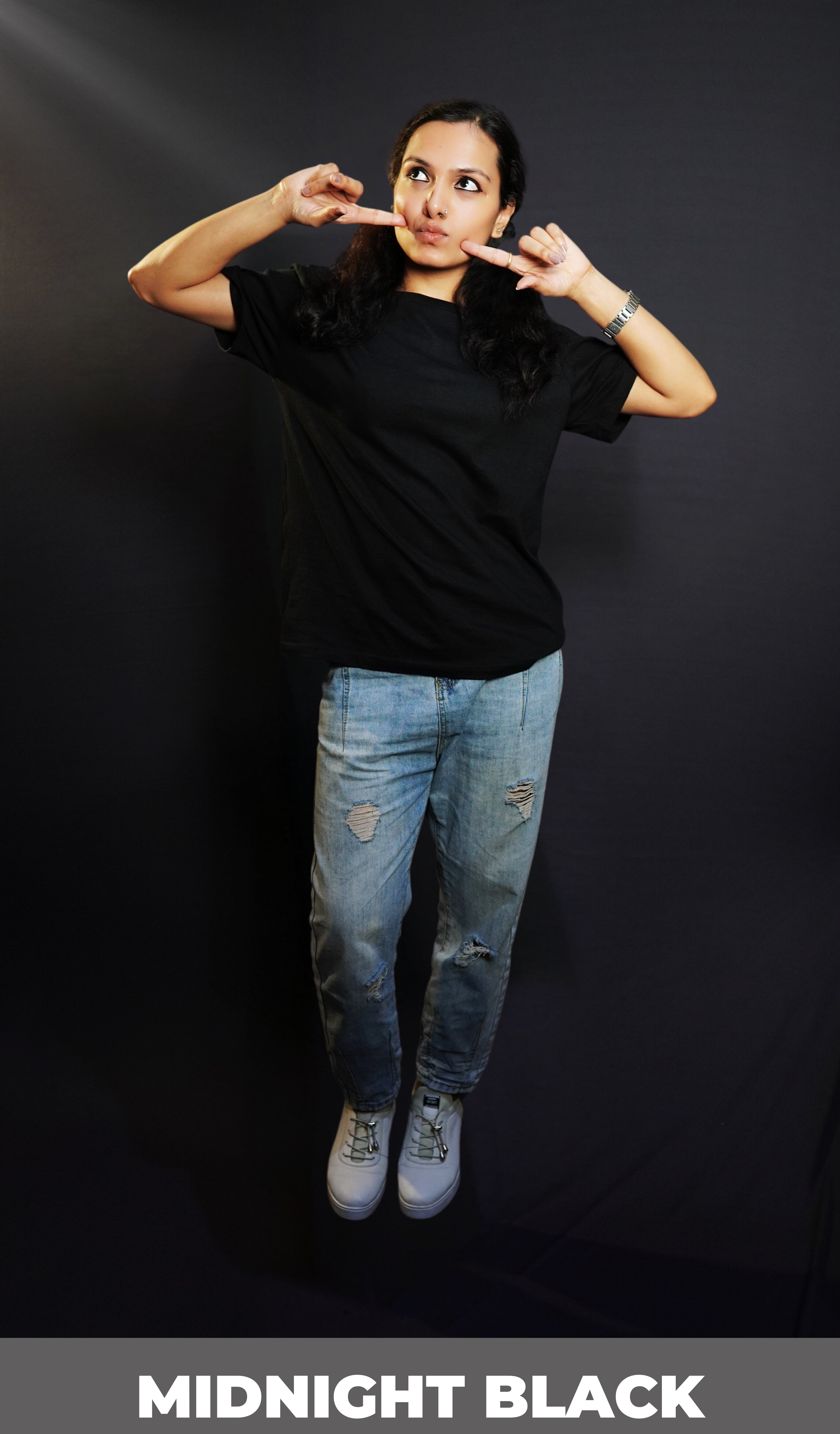 A woman in a plain adult's midnight black t-shirt with round neck, short sleeves and long length, posing with her fingers poking her cheeks, pouting a little, highlighting a cute informal look-Muselot