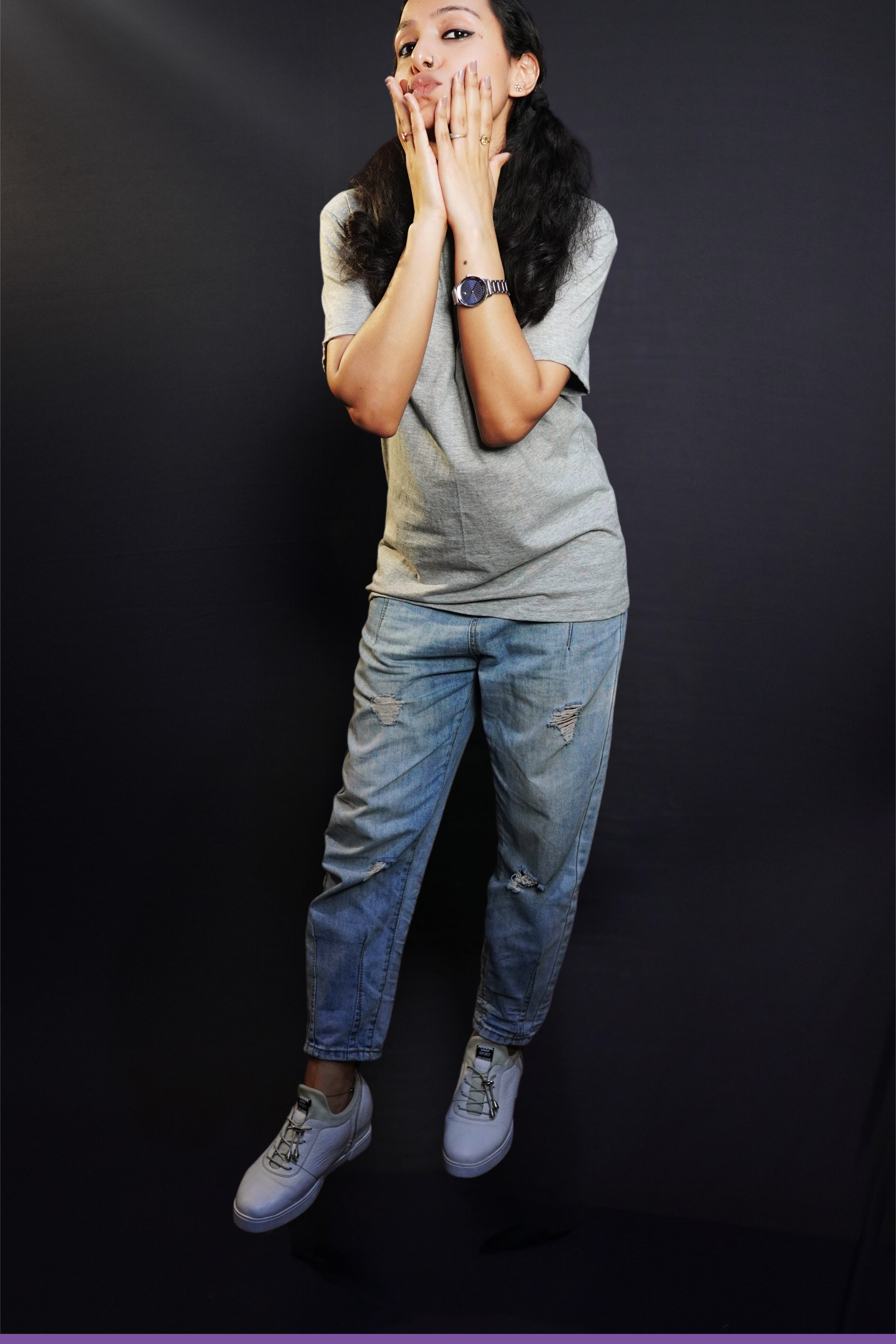 A woman posing with her hands on her cheeks, pouting as she slightly bends forward, wearing a misty grey plain unisex round neck t-shirt, showcasing a cute trendy look-Muselot
