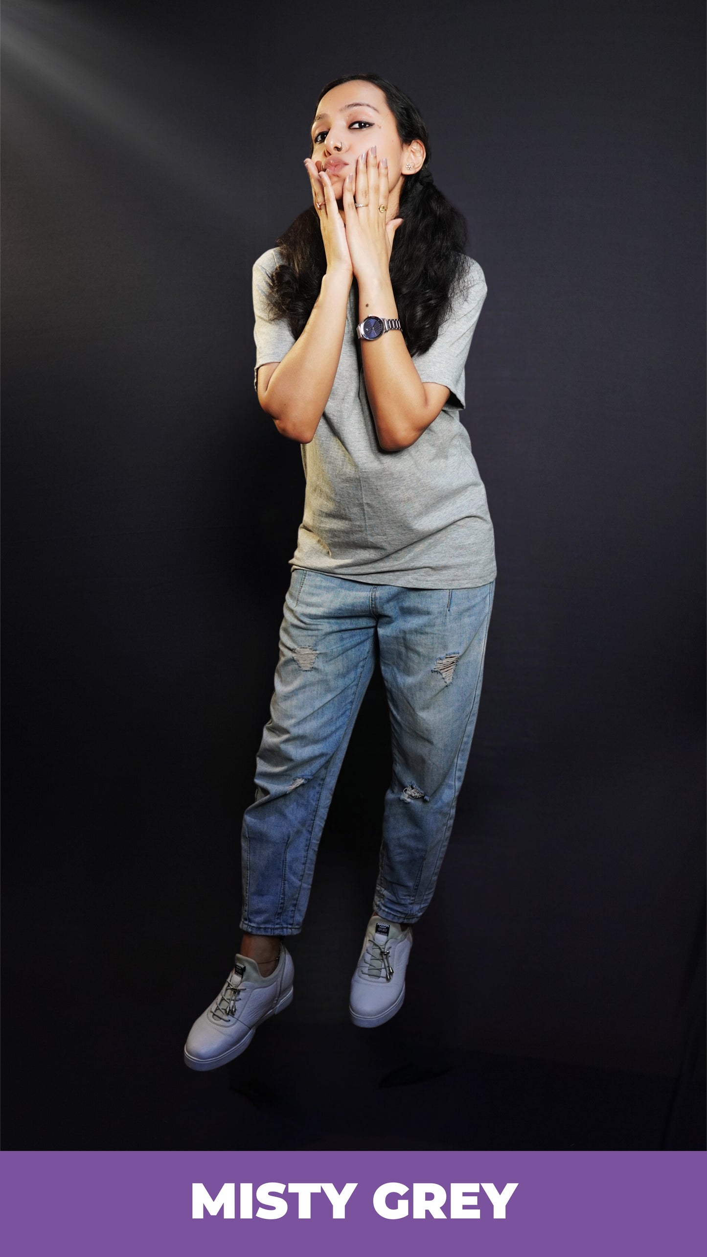 A woman posing with her hands on her cheeks, pouting as she slightly bends forward, wearing a misty grey plain unisex round neck t-shirt, showcasing a cute trendy look-Muselot