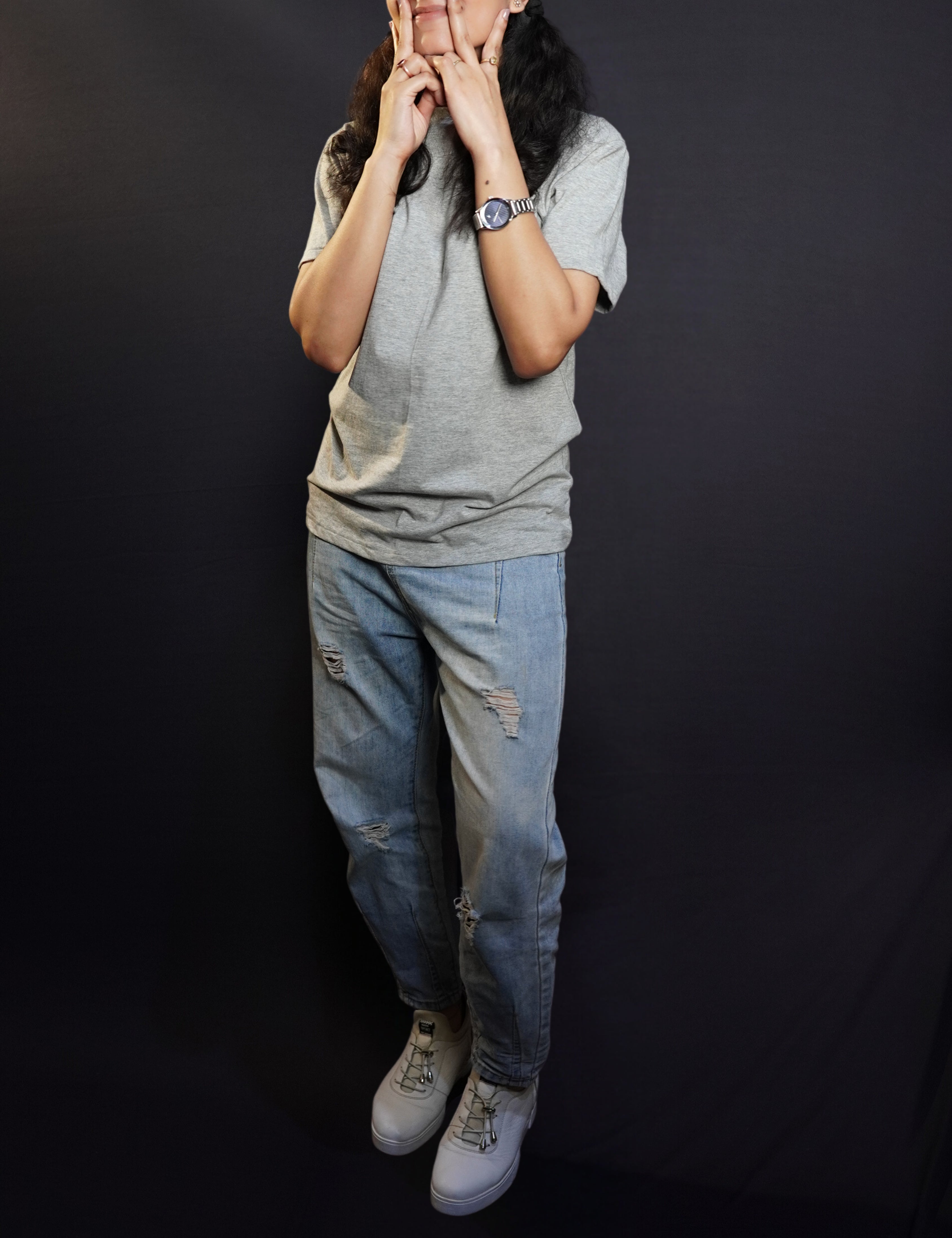 A woman wearing a long length round neck short sleeved plain t-shirt, posing with her hand on her cheeks making a v with her fingers, showcasing a soft homey fit-Muselot