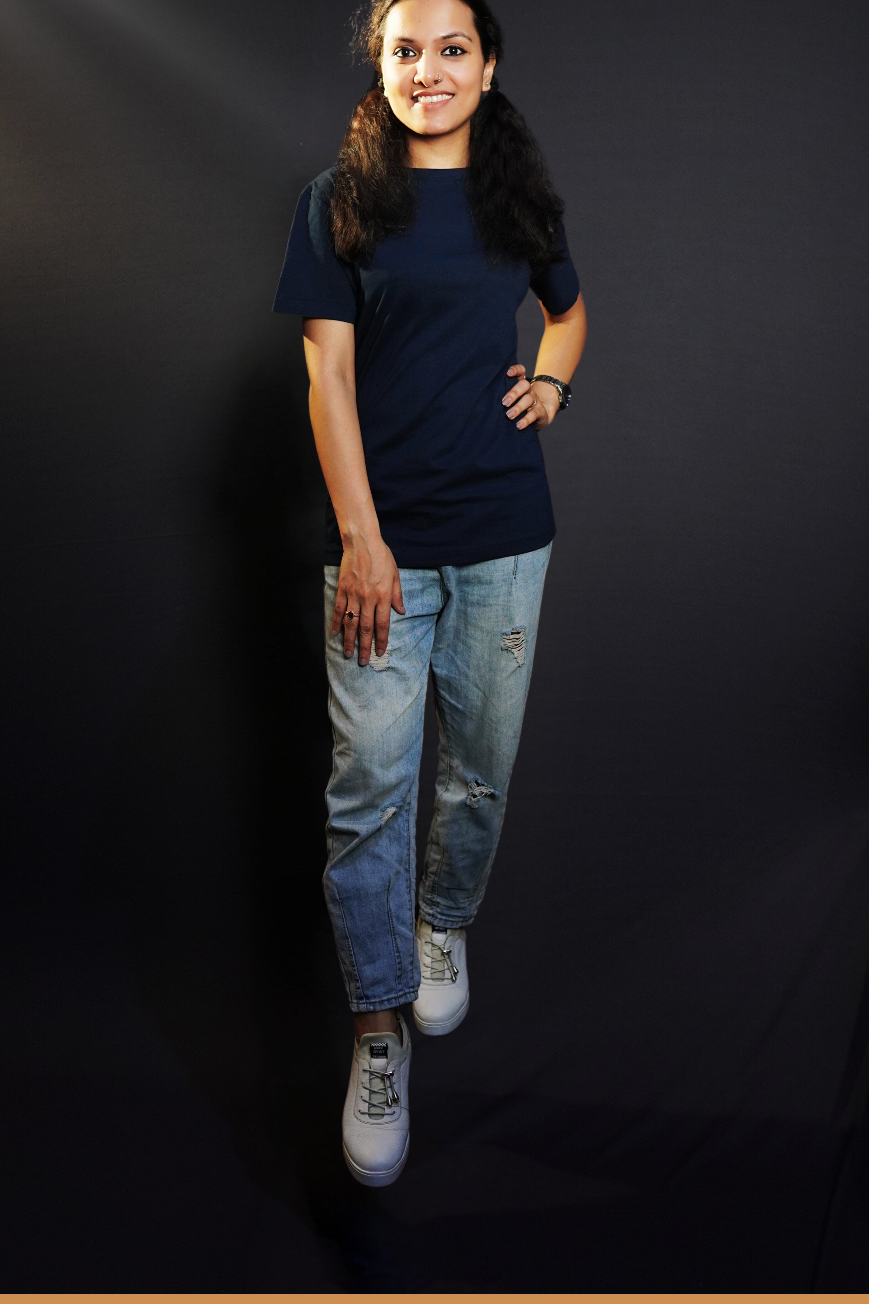 A stylish model wearing a unisex plain round neck navy blue t-shirt, posing with her hand on her waist and other on her thigh, showcasing a trendy snug fit-Muselot