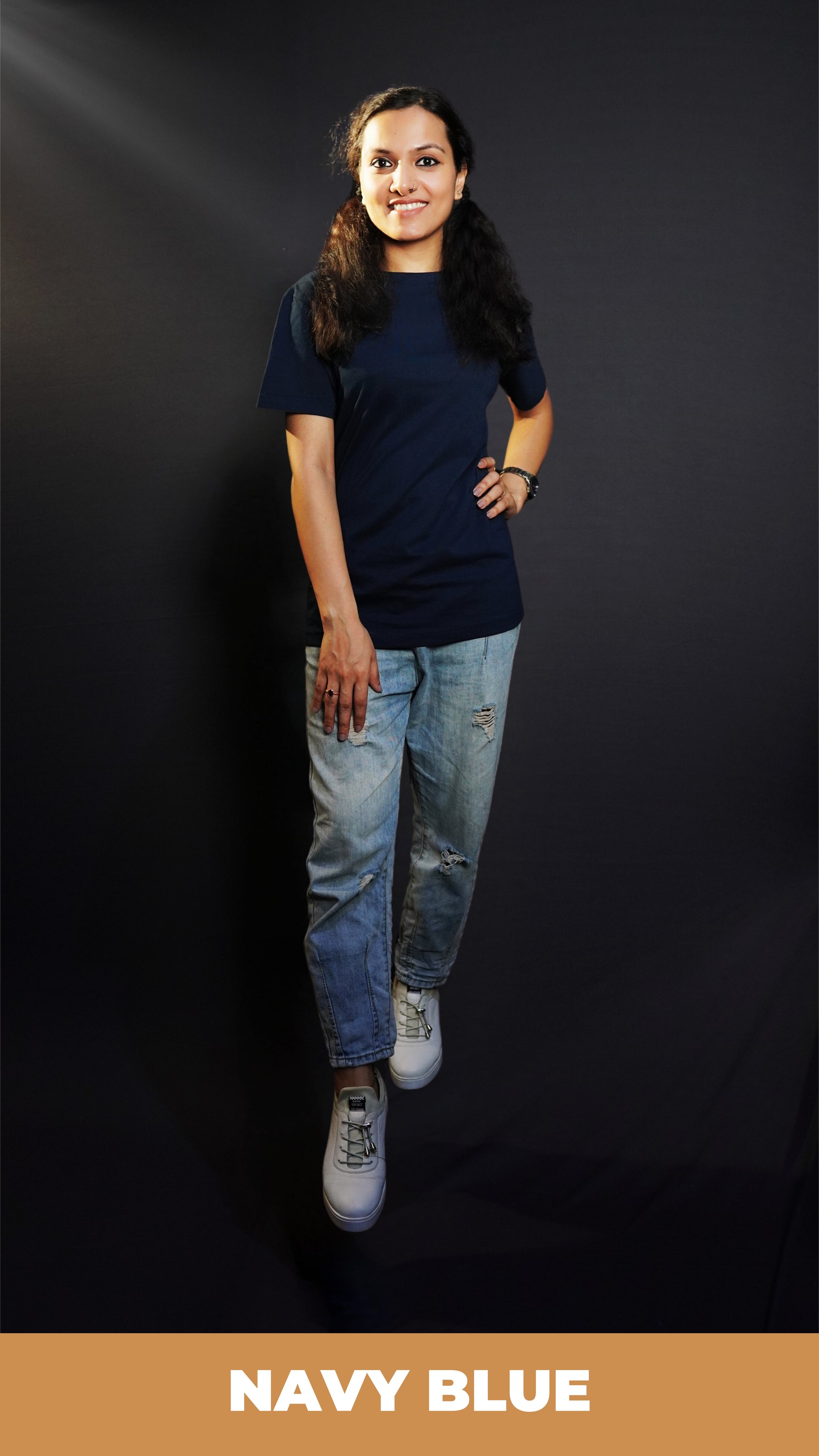 A stylish model wearing a unisex plain round neck navy blue t-shirt, posing with her hand on her waist and other on her thigh, showcasing a trendy snug fit-Muselot