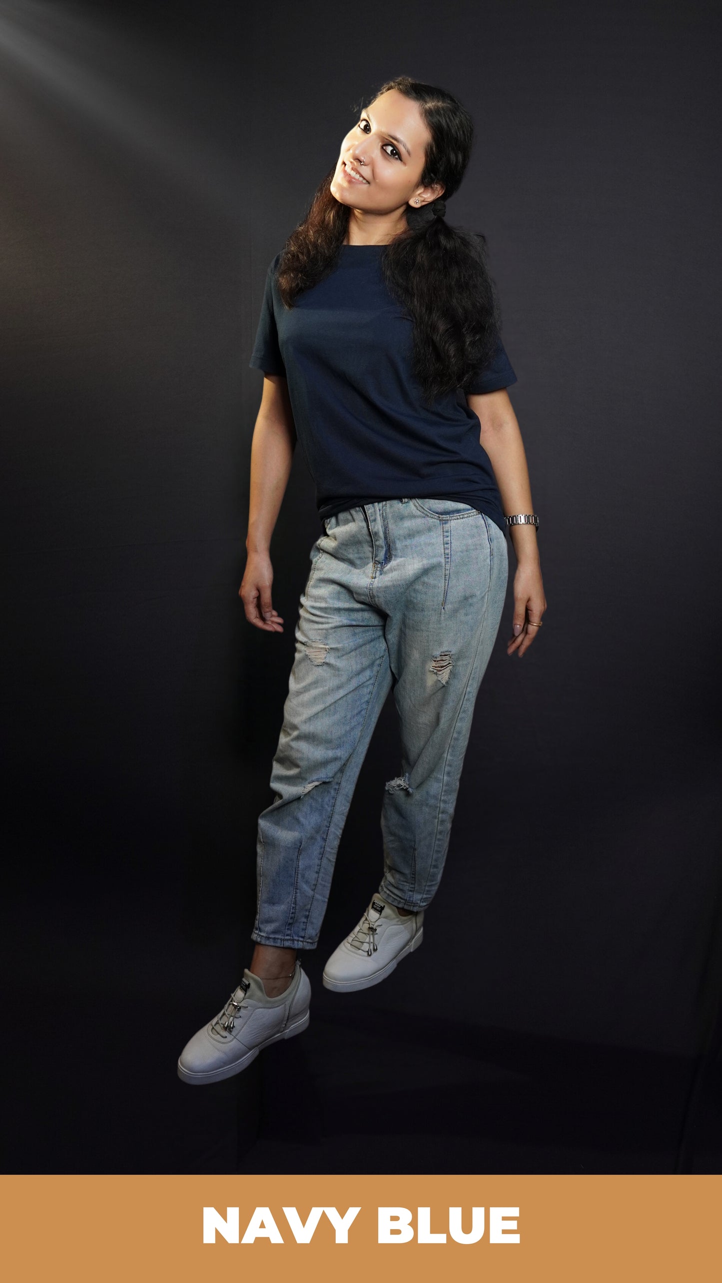 A woman wearing a girl's plain cotton round neck long length navy blue t-shirt, posing with her hands hanging on her sides, showcasing a popular relaxed fit-Muselot