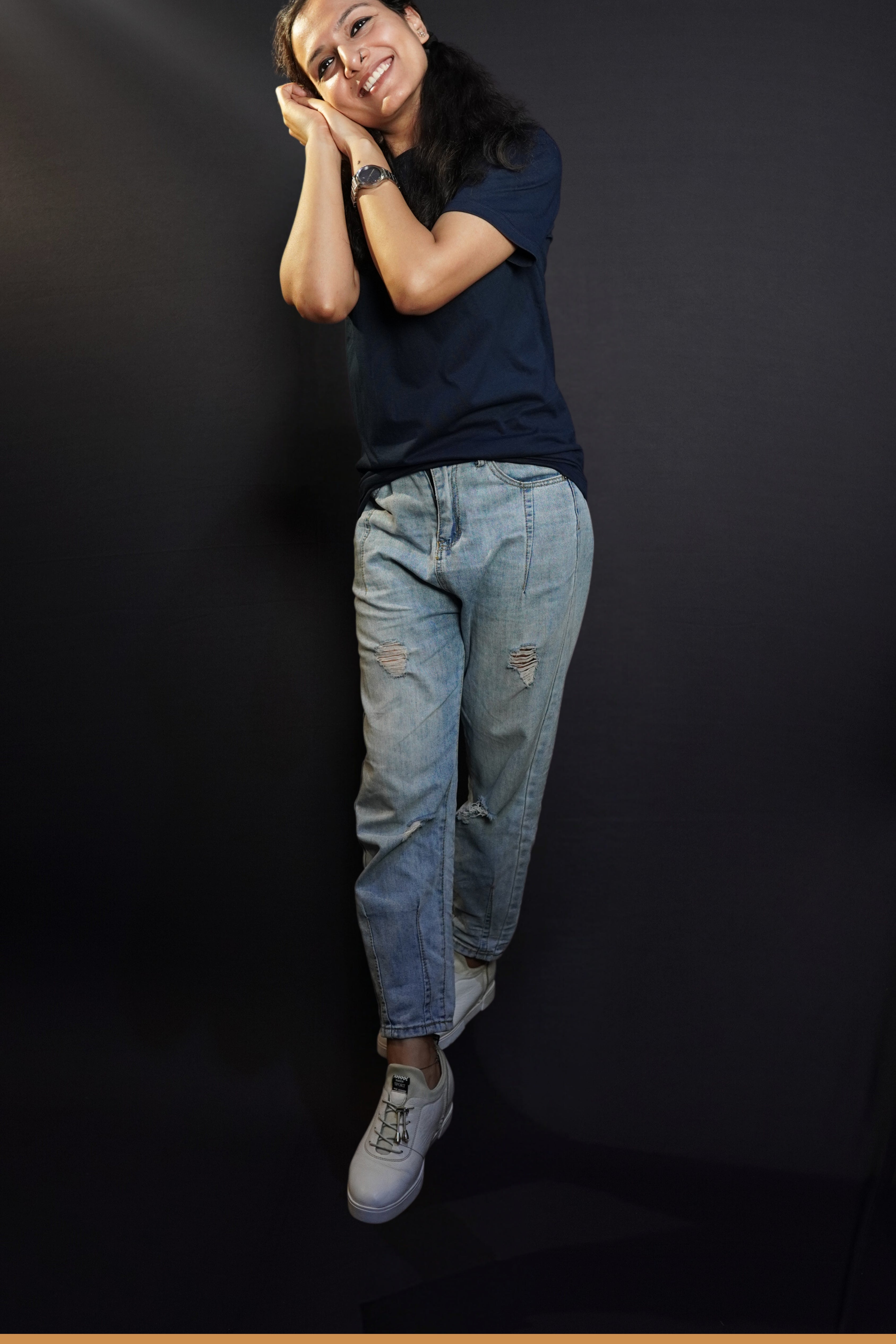 A woman wearing a long length plus size cotton summer navy blue t-shirt, posing with her hands making a pillow below her cheek, showcasing a swank loose fit-Muselot