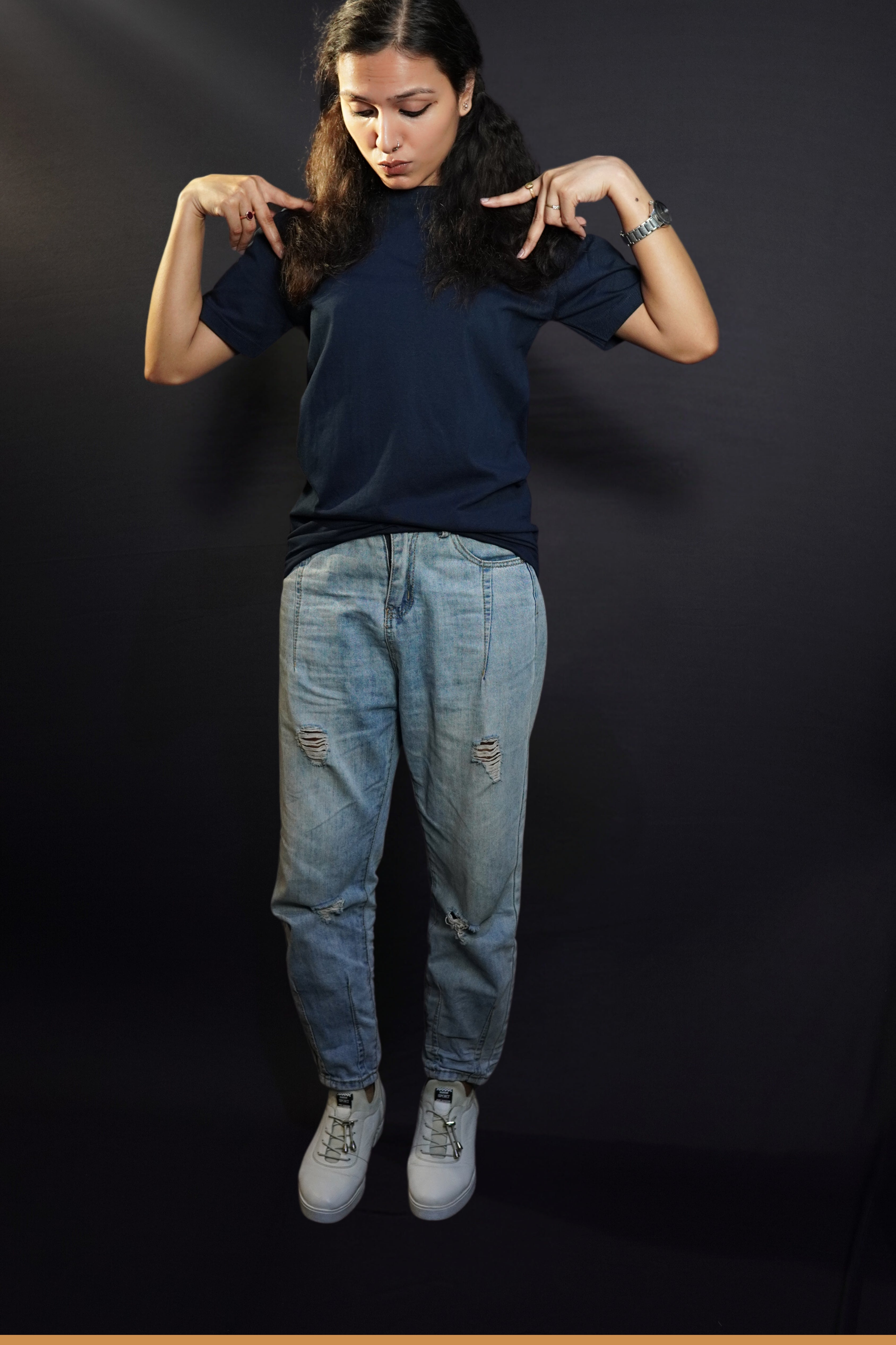 A woman wearing a round neck quick drying short sleeved navy blue t-shirt, posing with her hands making a v on her shoulder, showcasing a cool cozy fit-Muselot