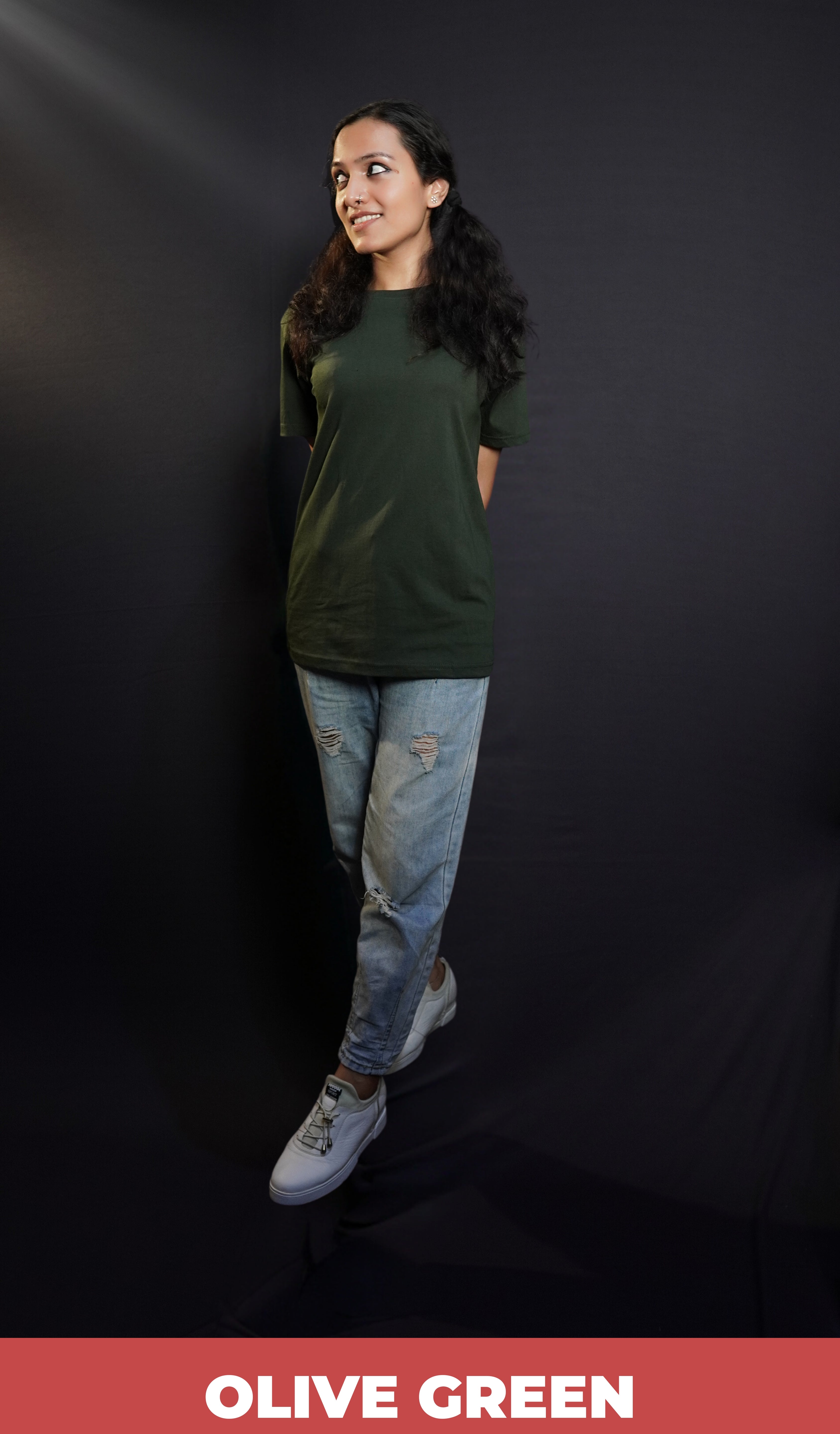 A woman wearing a women's cotton short sleeved olive green t-shirt, posing with her hands at her back as she stands slightly sideways, highlighting a relaxed casual fit-Muselot