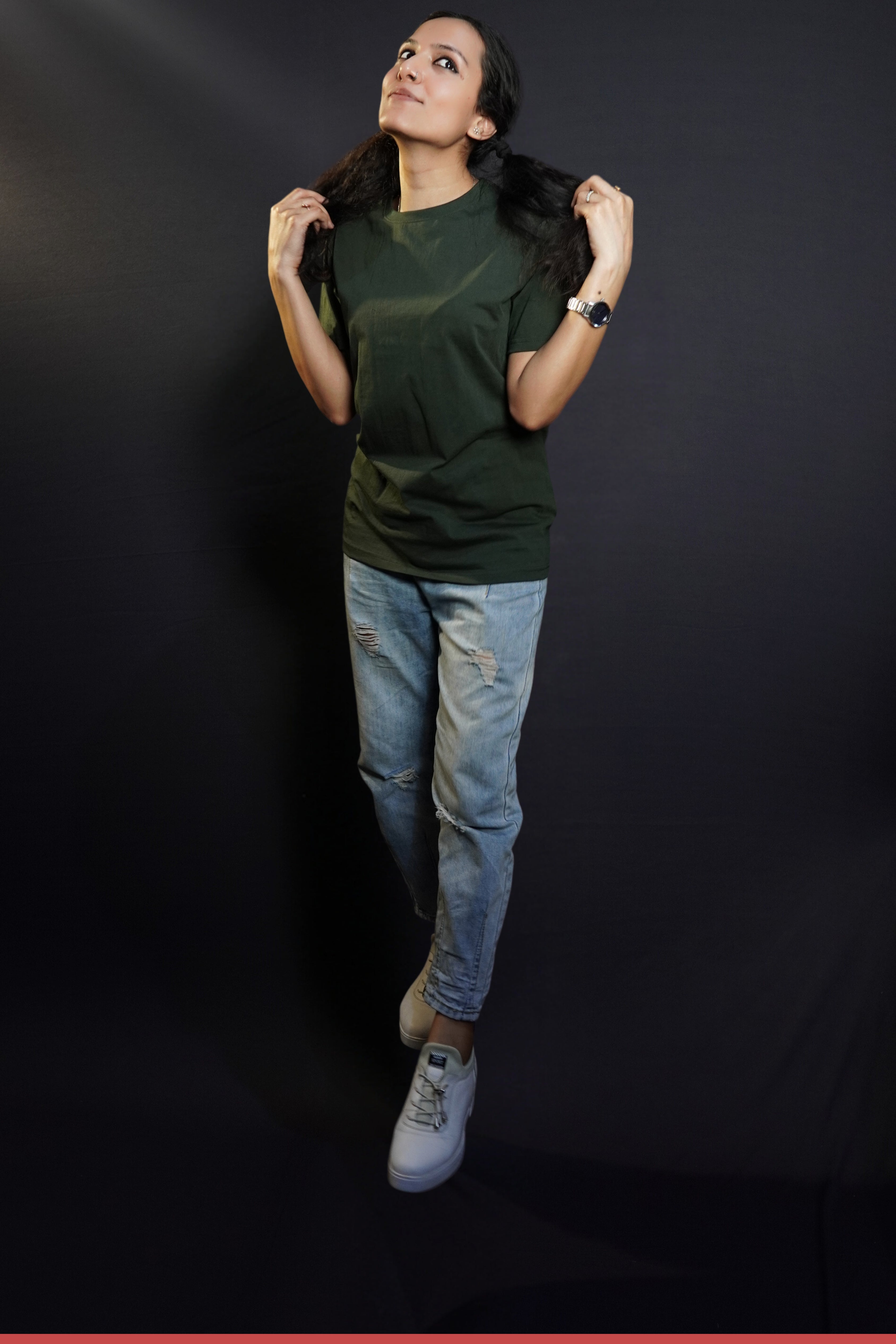 A woman wearing a plain round neck moisture wicking olive green t-shirt, posing with her hands pulling the sections of her hair, highlighting a fresh cozy look-Muselot