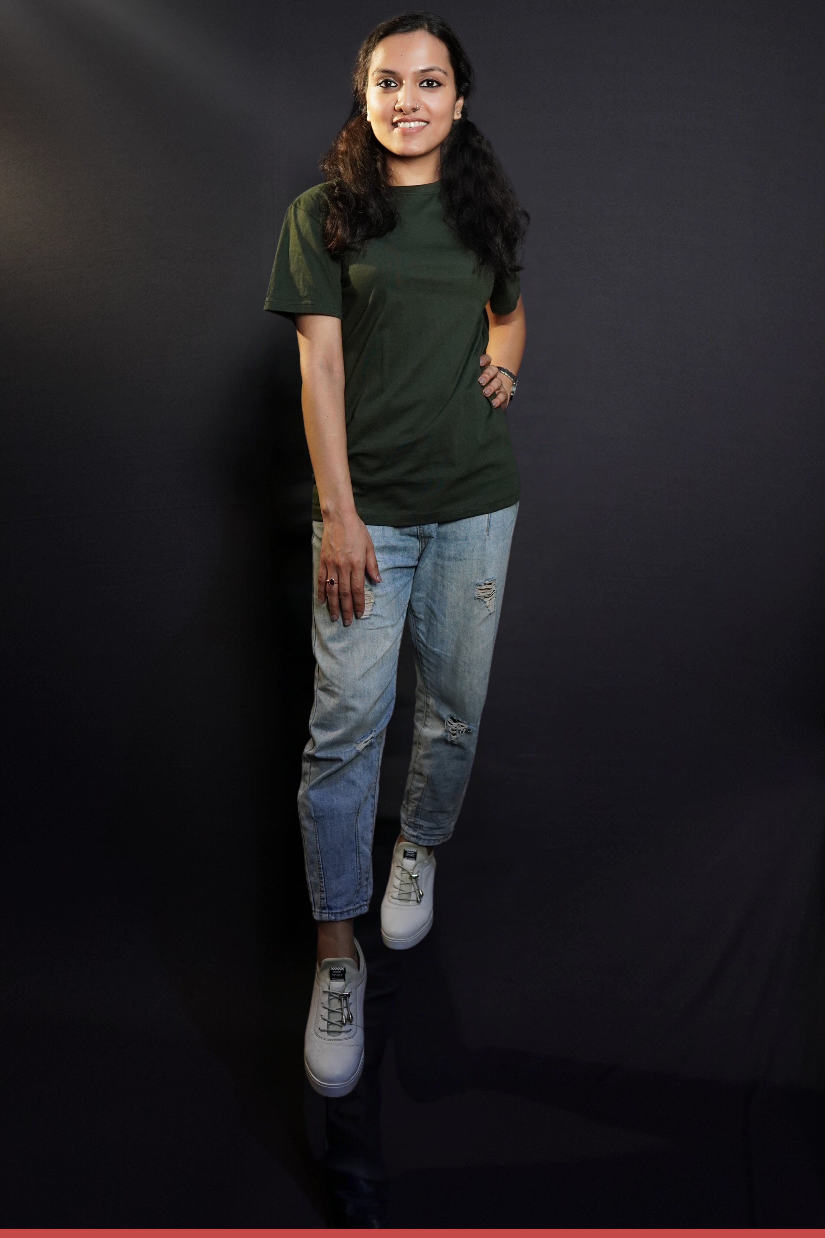 A stylish model wearing a short sleeved quick drying long length olive green t-shirt, posing with her hand on her waist and other on her thigh, showcasing a fashionable easygoing fit-Muselot