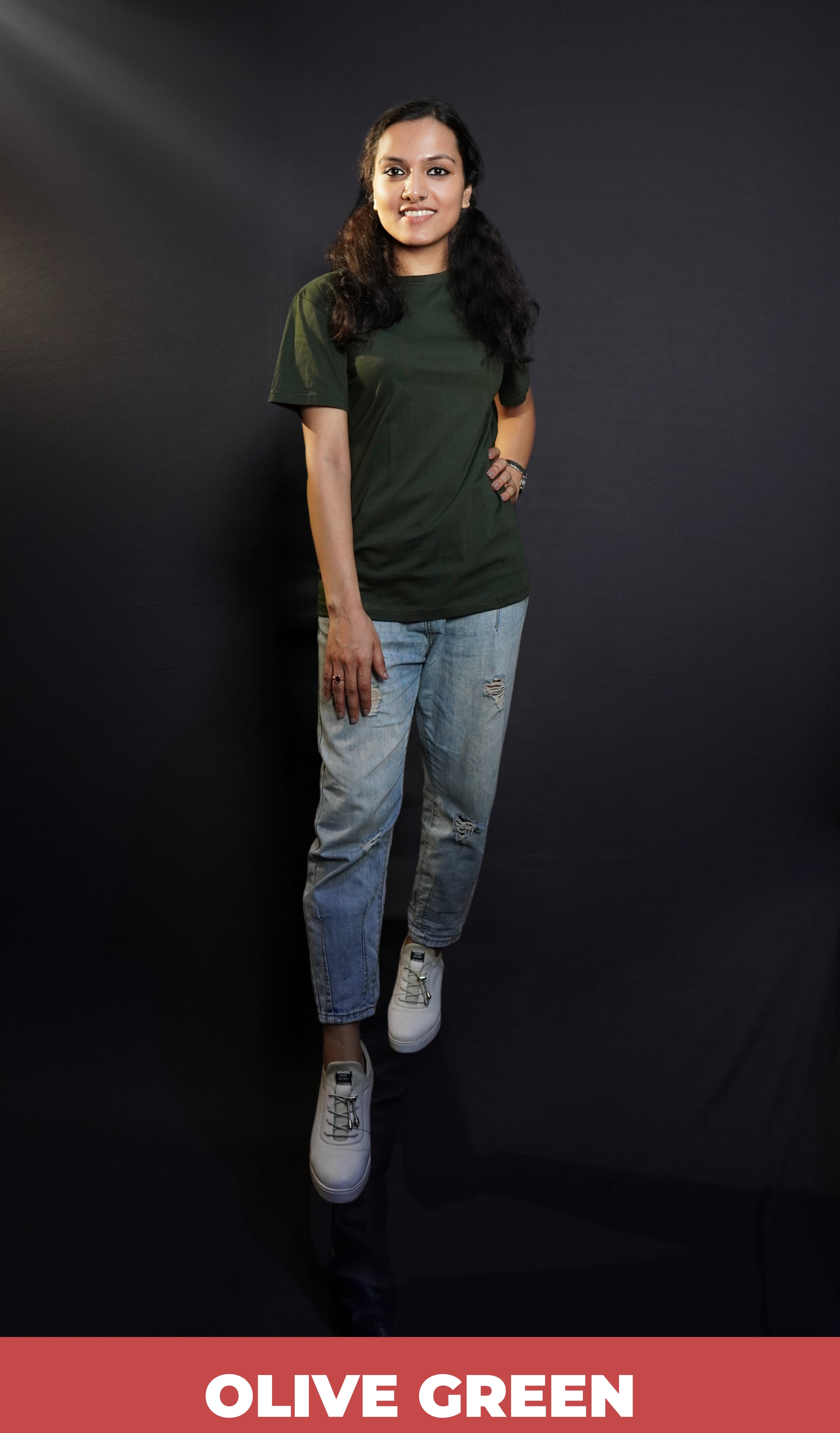 A stylish model wearing a short sleeved quick drying long length olive green t-shirt, posing with her hand on her waist and other on her thigh, showcasing a fashionable easygoing fit-Muselot