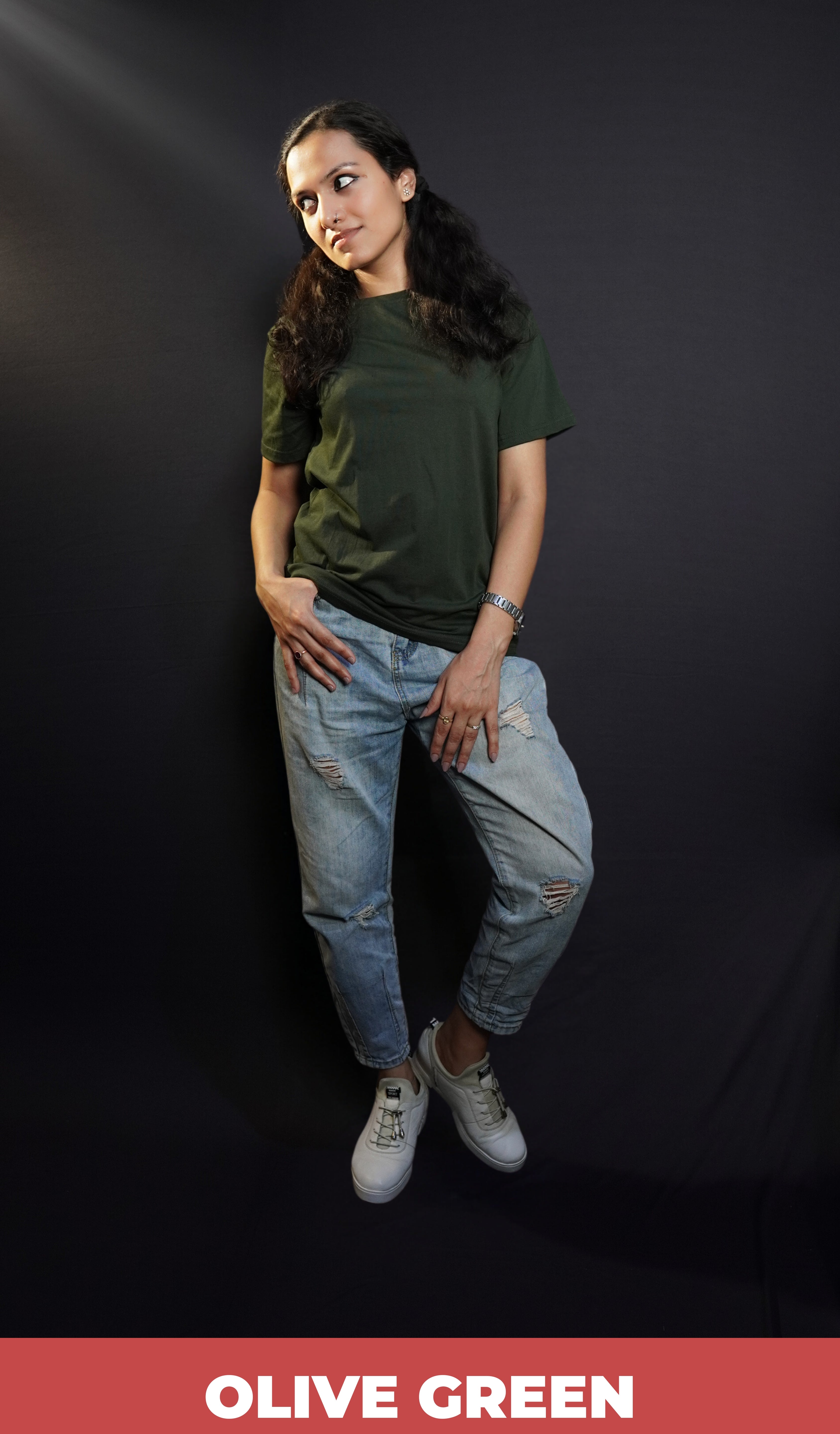 A woman posing with her hand on her pocket while she looks sideways, wearing a plain long length moisture wicking olive green t-shirt, showcasing an up to the minute loose fit-Muselot