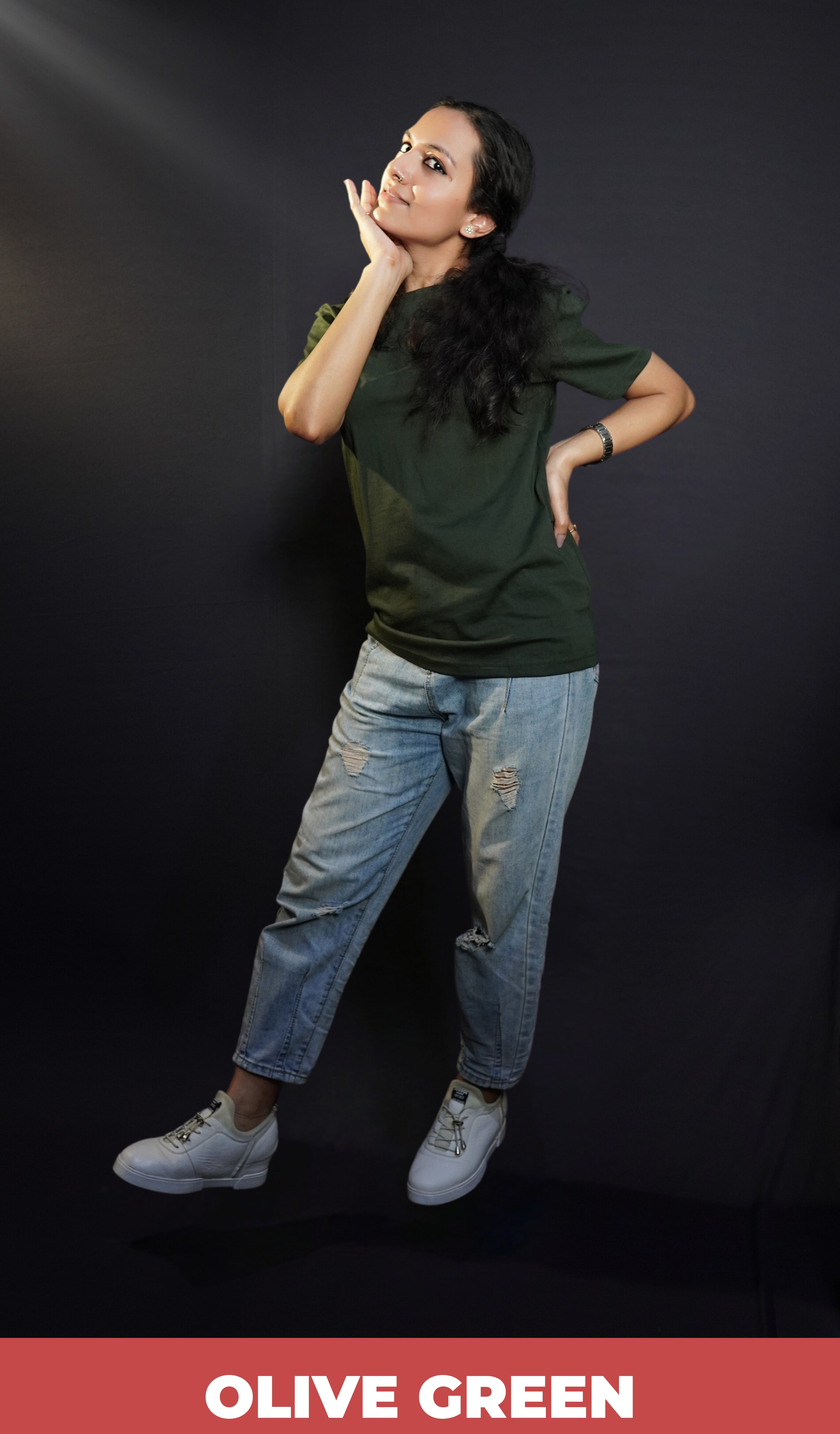 A woman with her hand under her chin and other on her waist, wearing a plus size short sleeved quick drying olive green t-shirt, highlighting an in demand baggy fit-Muselot