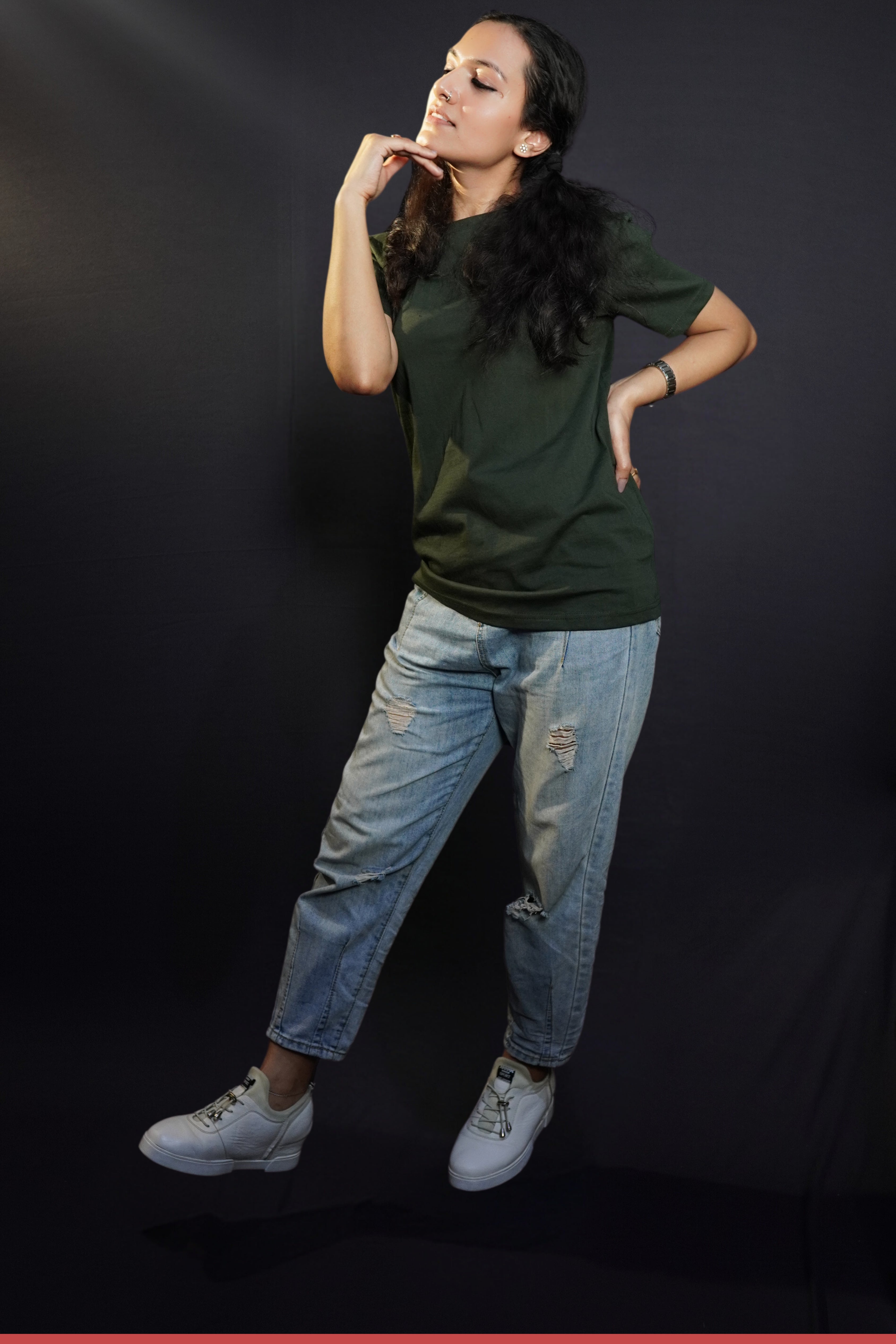 A woman posing with her hand under her chin and other on her waist, wearing a girl's plain stretchable round neck olive green t-shirt, showcasing a popular perfect fit-Muselot