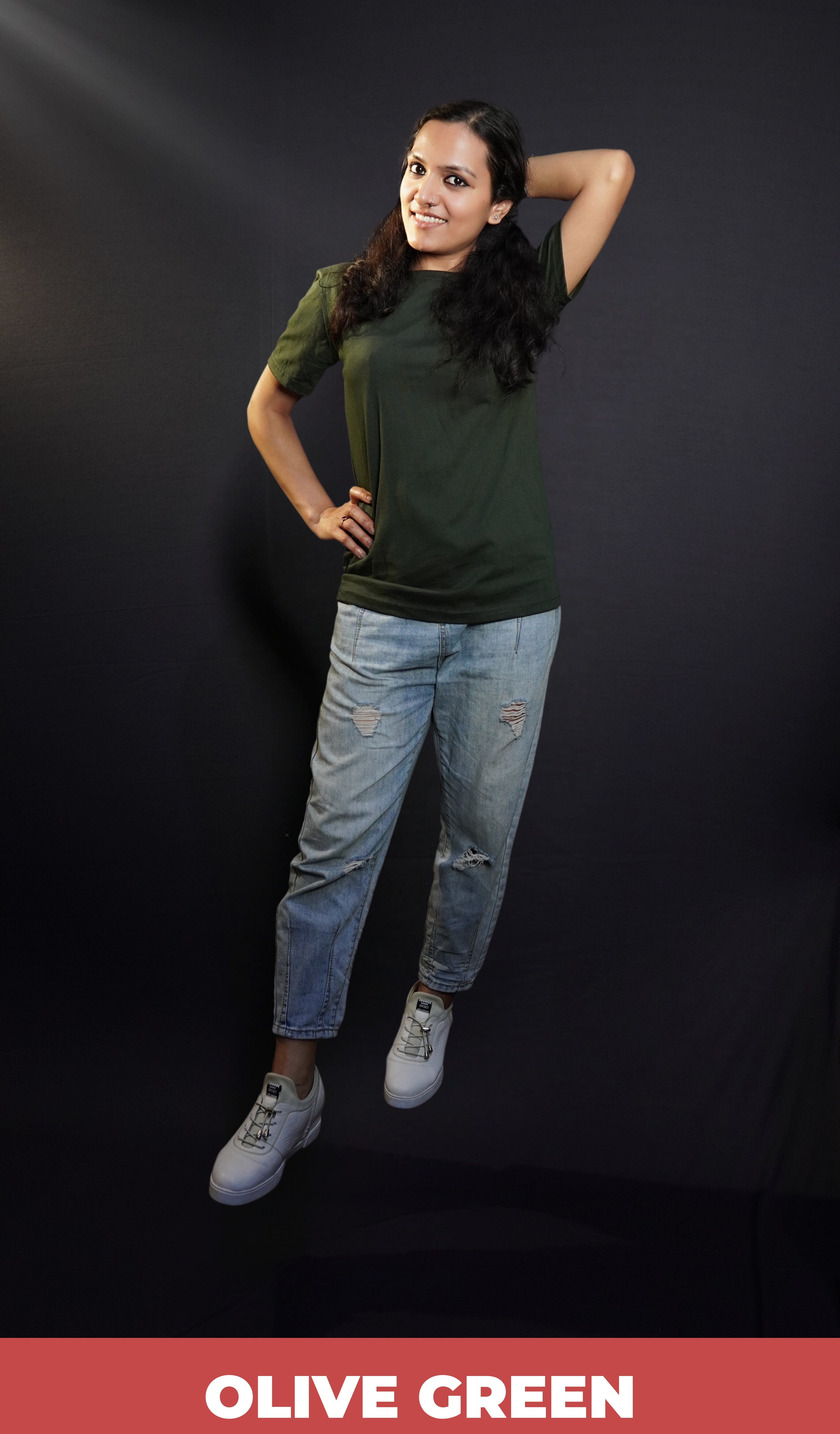 A woman wearing men's plain long length summer olive green t-shirt, posing with her hand up behind her head and other on her waist, highlighting a modern voguish look-Muselot