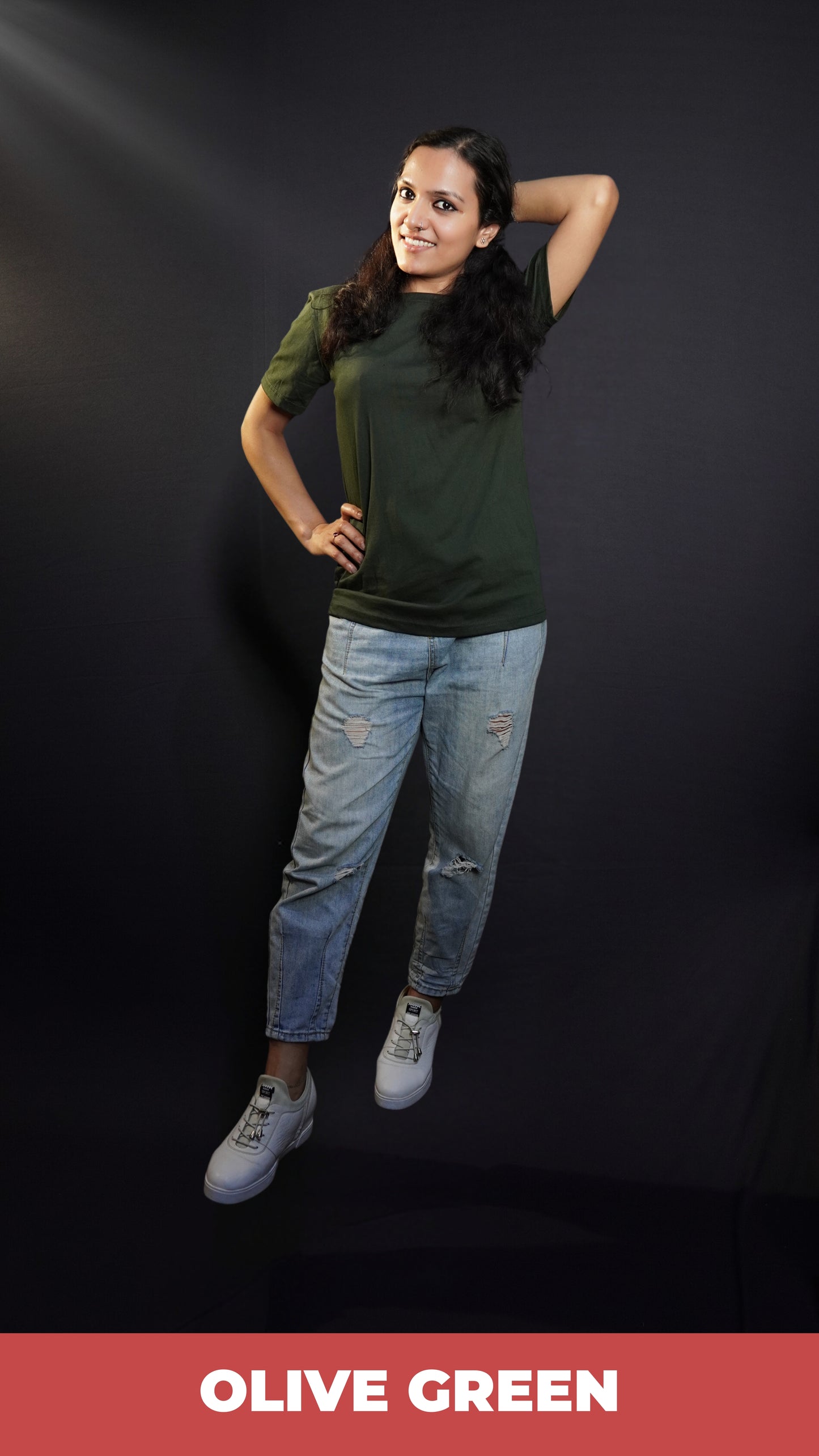 A woman wearing men's plain long length summer olive green t-shirt, posing with her hand up behind her head and other on her waist, highlighting a modern voguish look-Muselot