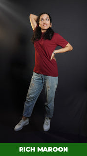 A woman posing with her hand up and behind her head and another on her waist, wearing a long length short sleeved moisture wicking rich maroon t-shirt, showcasing a loose flowing fit-Muselot