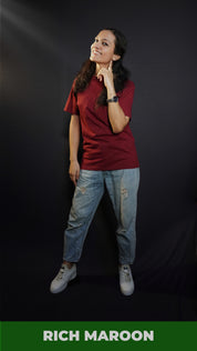 A woman wearing a girl's round neck stretchable rich maroon t-shirt, posing with her finger under her ear and other hanging on her side, showcasing a cool cozy look-Muselot