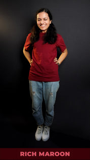 A cute model laughing hard posing with her hands on her waist, wearing a short sleeved quick drying round neck rich maroon t-shirt, showcasing a modish in vogue look-Muselot