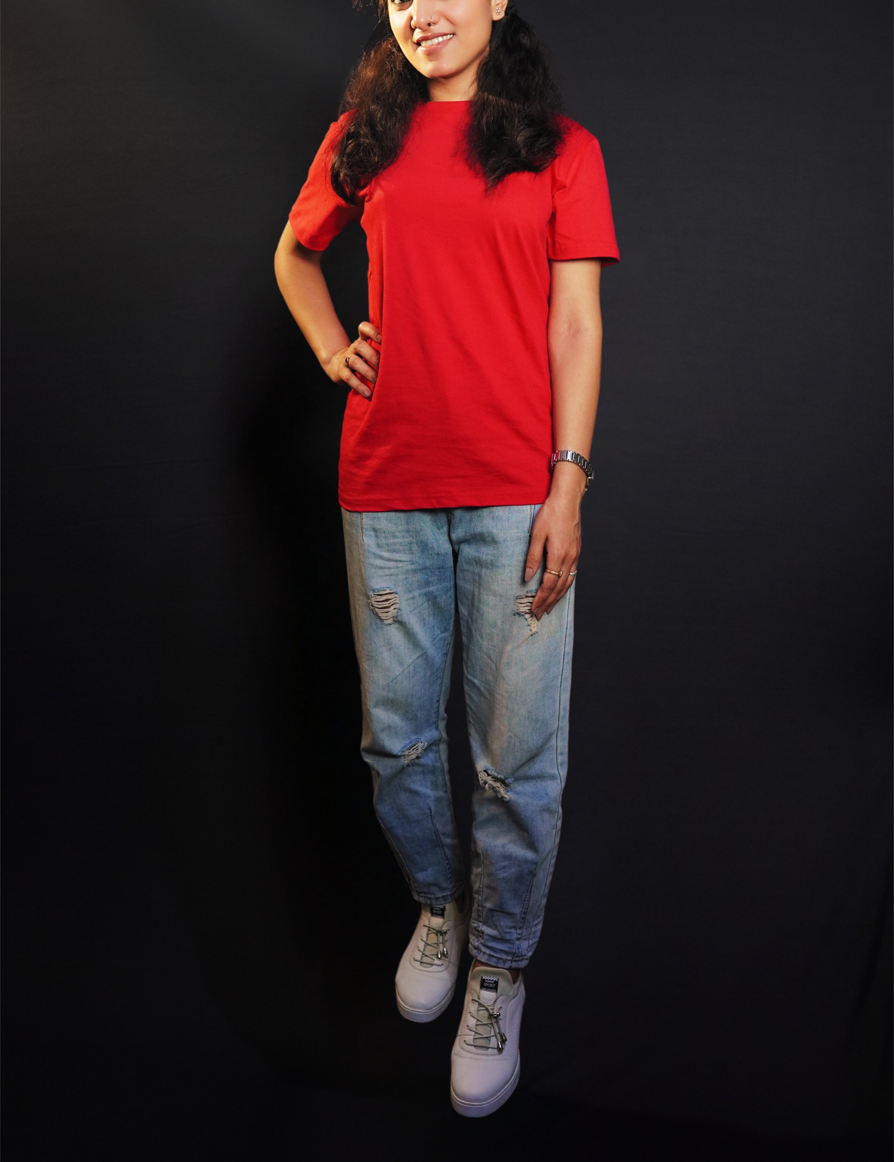 A stylish model standing straight as her hand hangs on her side and another on her waist, wearing a unisex plain rosy red round neck t-shirt. showcasing a fashionable in vogue look-Muselot