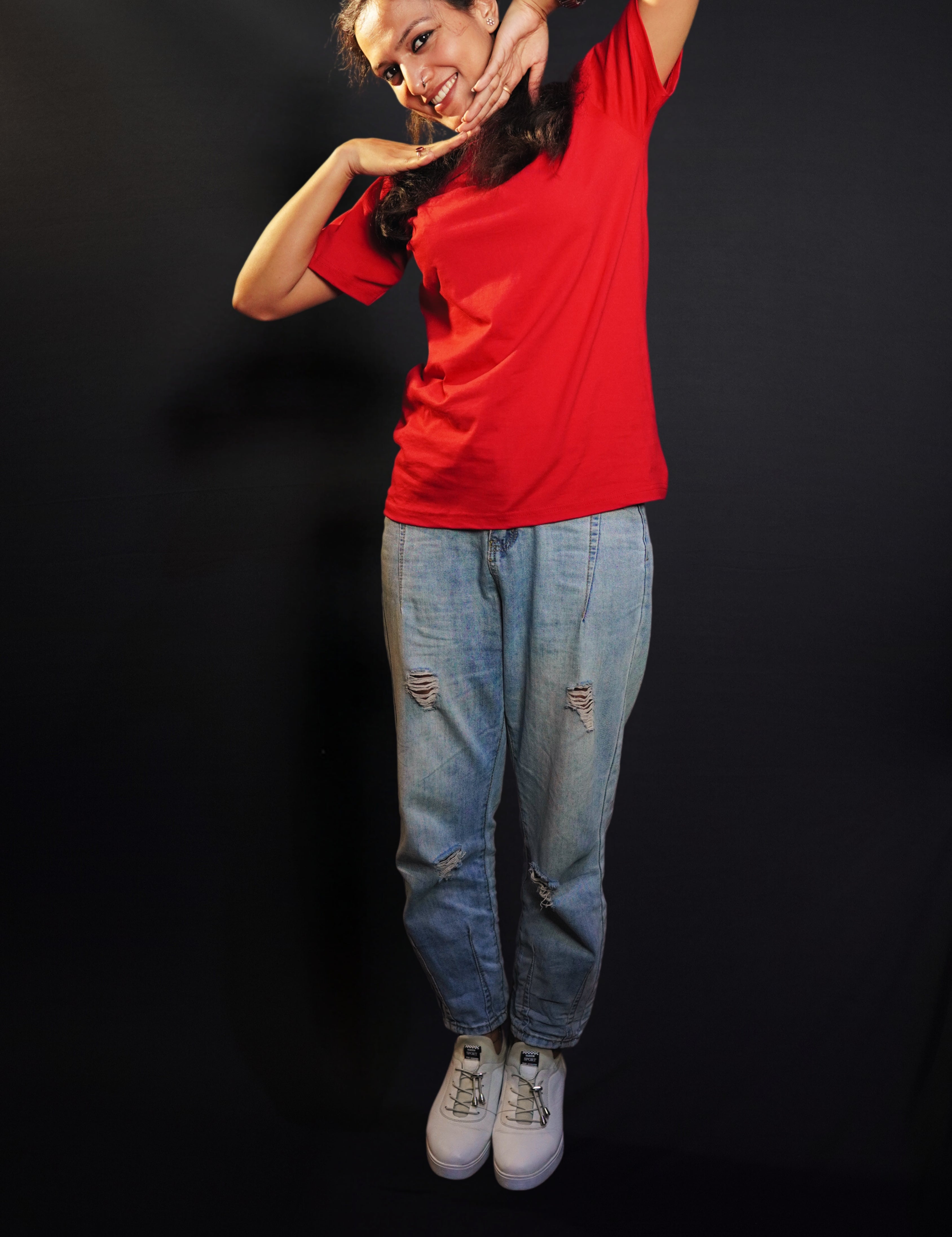 A happy woman wearing an adult's summer round neck moisture wicking rosy red t-shirt, posing with her hands below her chin, smiling happily, highlighting an aesthetic cozy look-Muselot