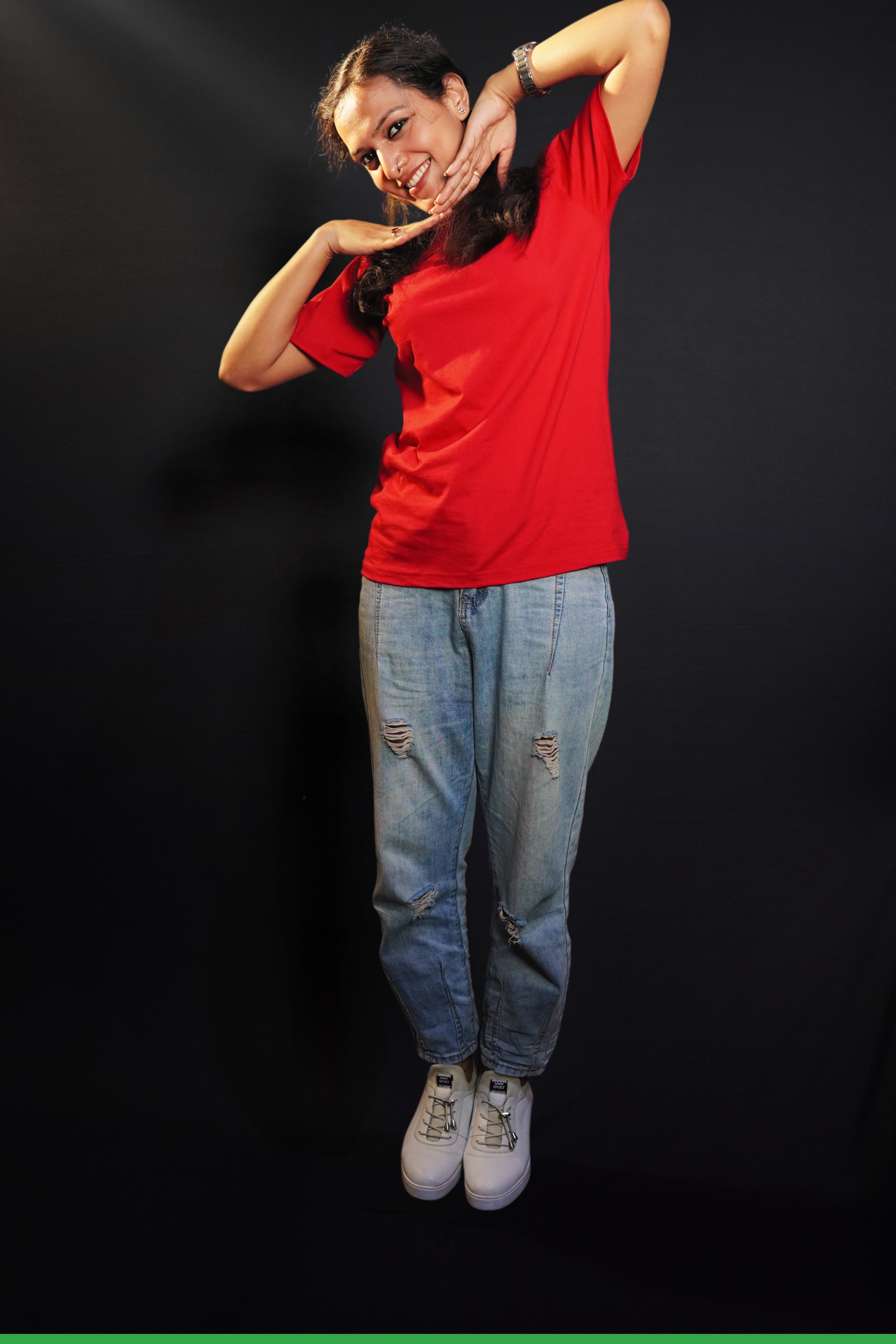 A happy woman wearing an adult's summer round neck moisture wicking rosy red t-shirt, posing with her hands below her chin, smiling happily, highlighting an aesthetic cozy look-Muselot