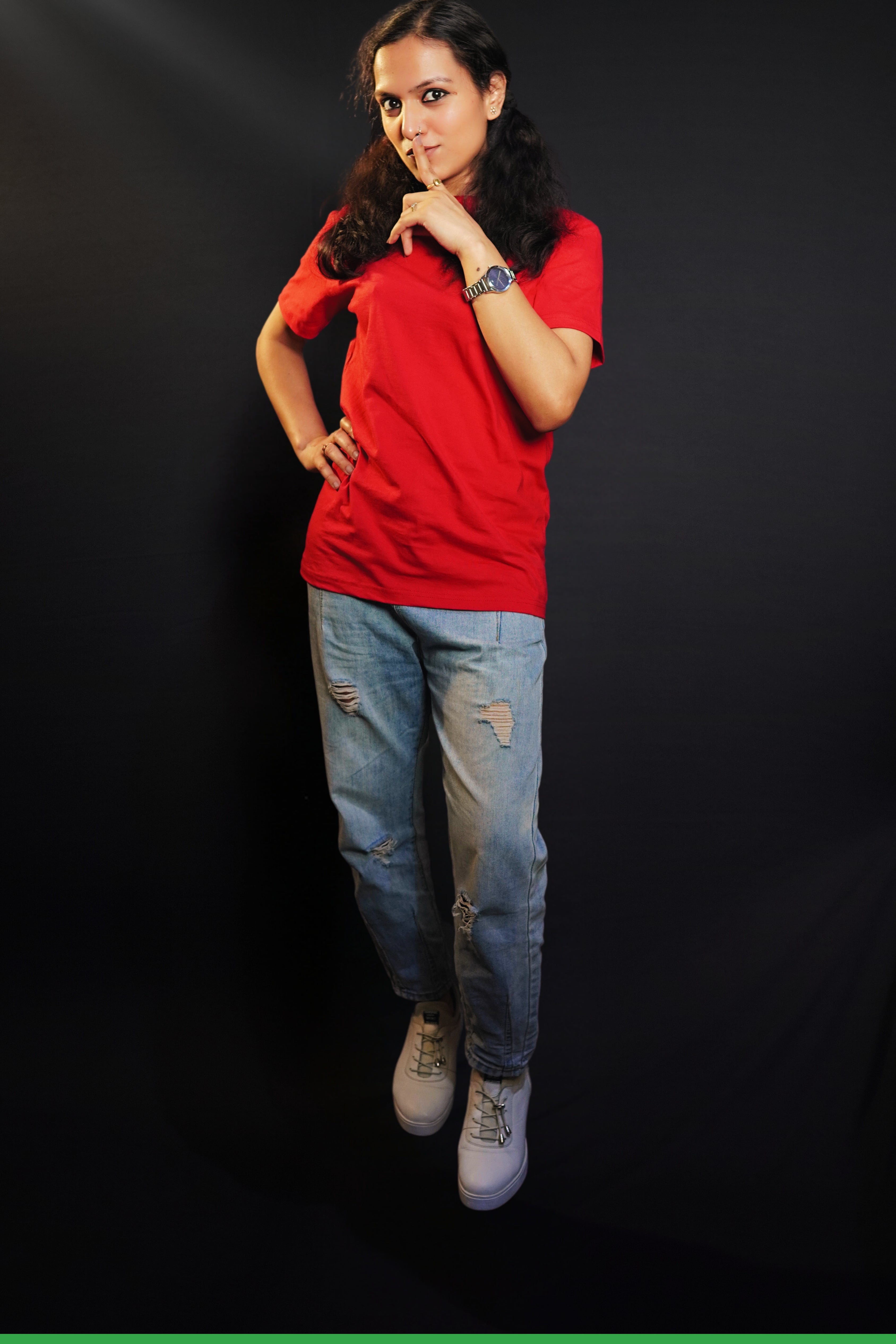 A woman posing with her finger on her lips and a hand on her waist, wearing a plus size round neck stretchable rosy red t-shirt, showcasing a popular easygoing fit-Muselot