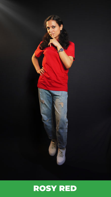 A woman posing with her finger on her lips and a hand on her waist, wearing a plus size round neck stretchable rosy red t-shirt, showcasing a popular easygoing fit-Muselot