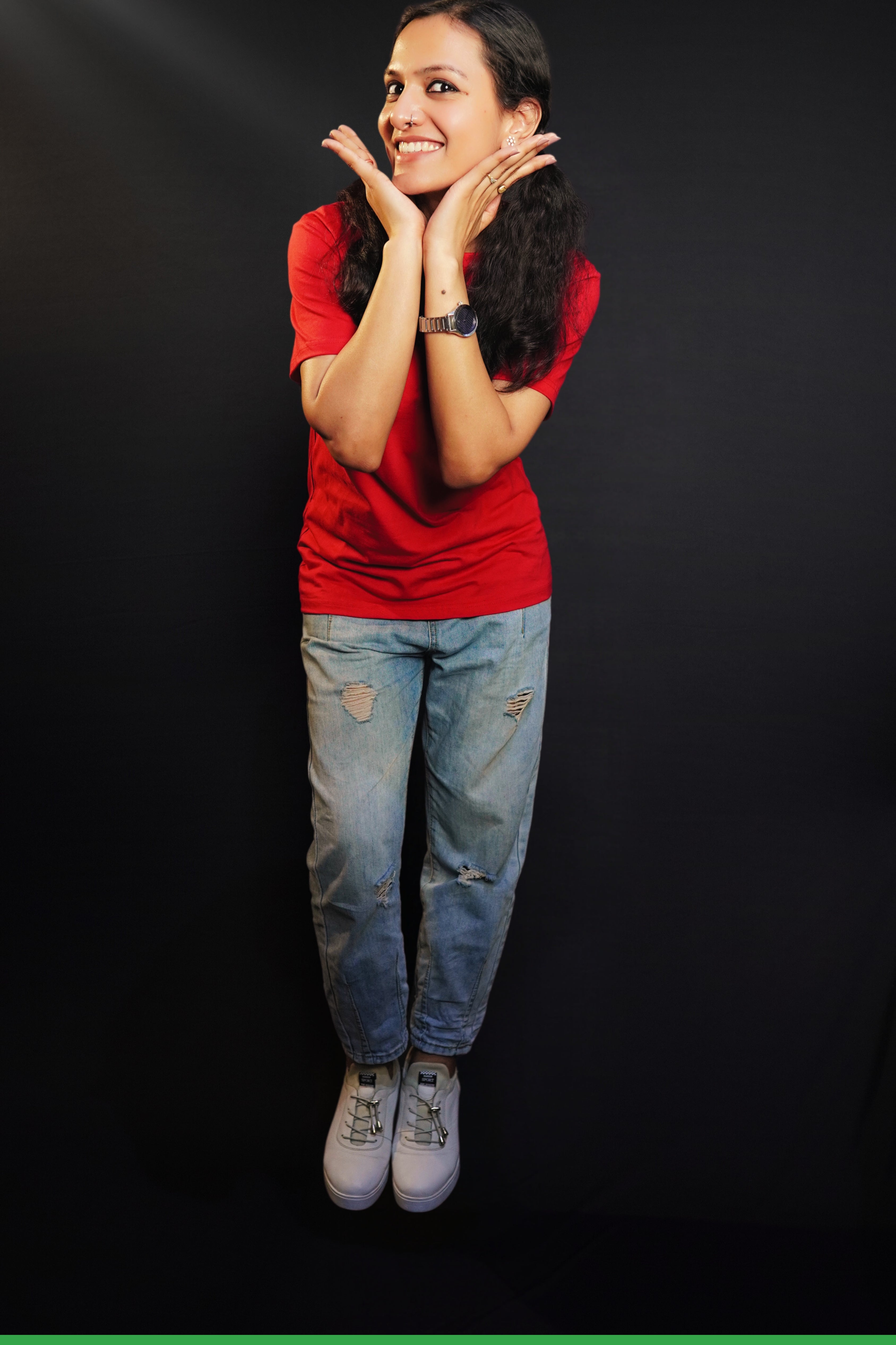 A woman posing happily with her hands under her chin as she bends slightly forward, wearing a summer rosy red t-shirt with round neck and short sleeves, highlighting a casual cozy fit-Muselot