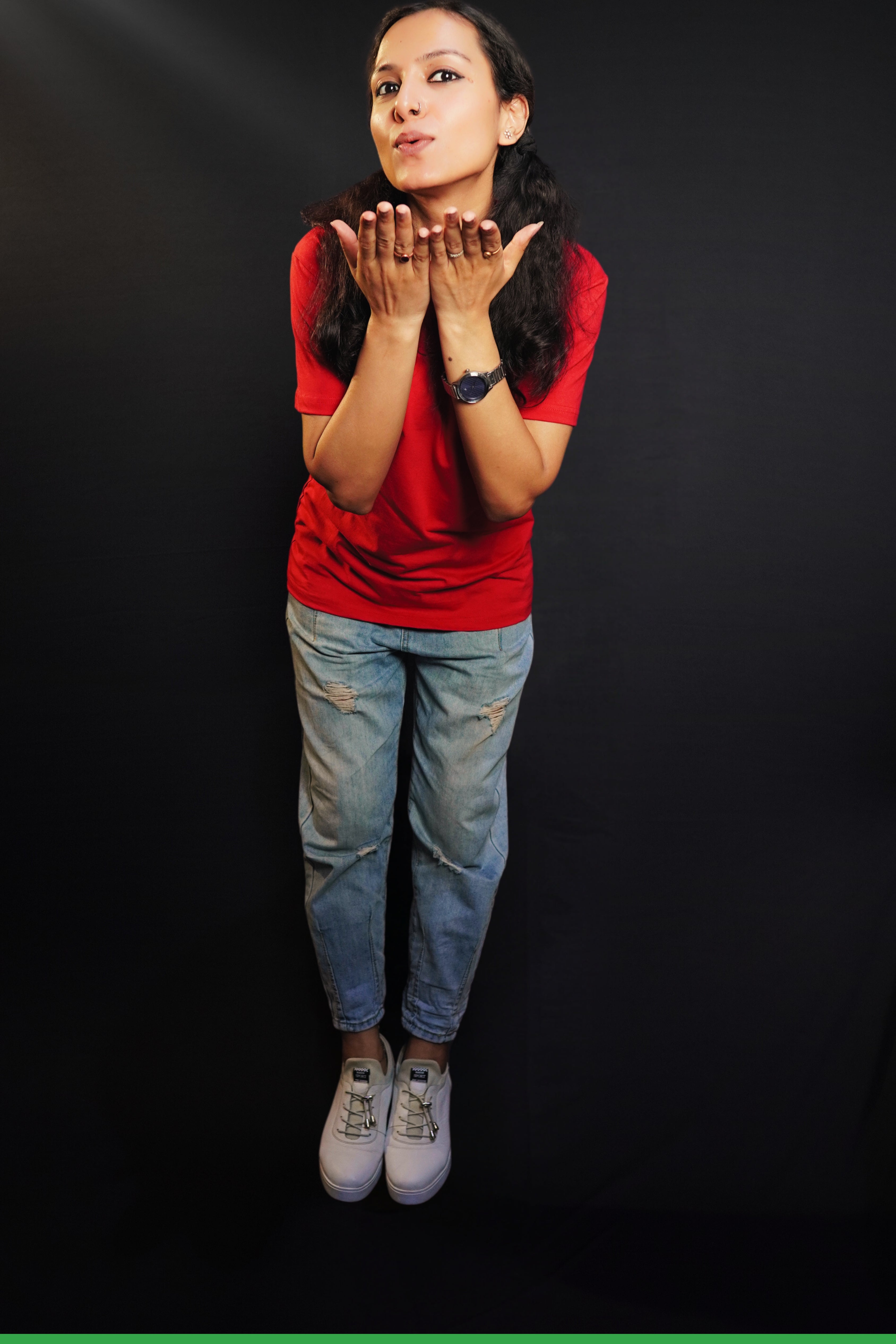 A woman wearing a plus size plain cotton stretchable t-shirt, posing as she offer a flying kiss with her palms stretched near her chin, showcasing a trendy baggy fit-Muselot