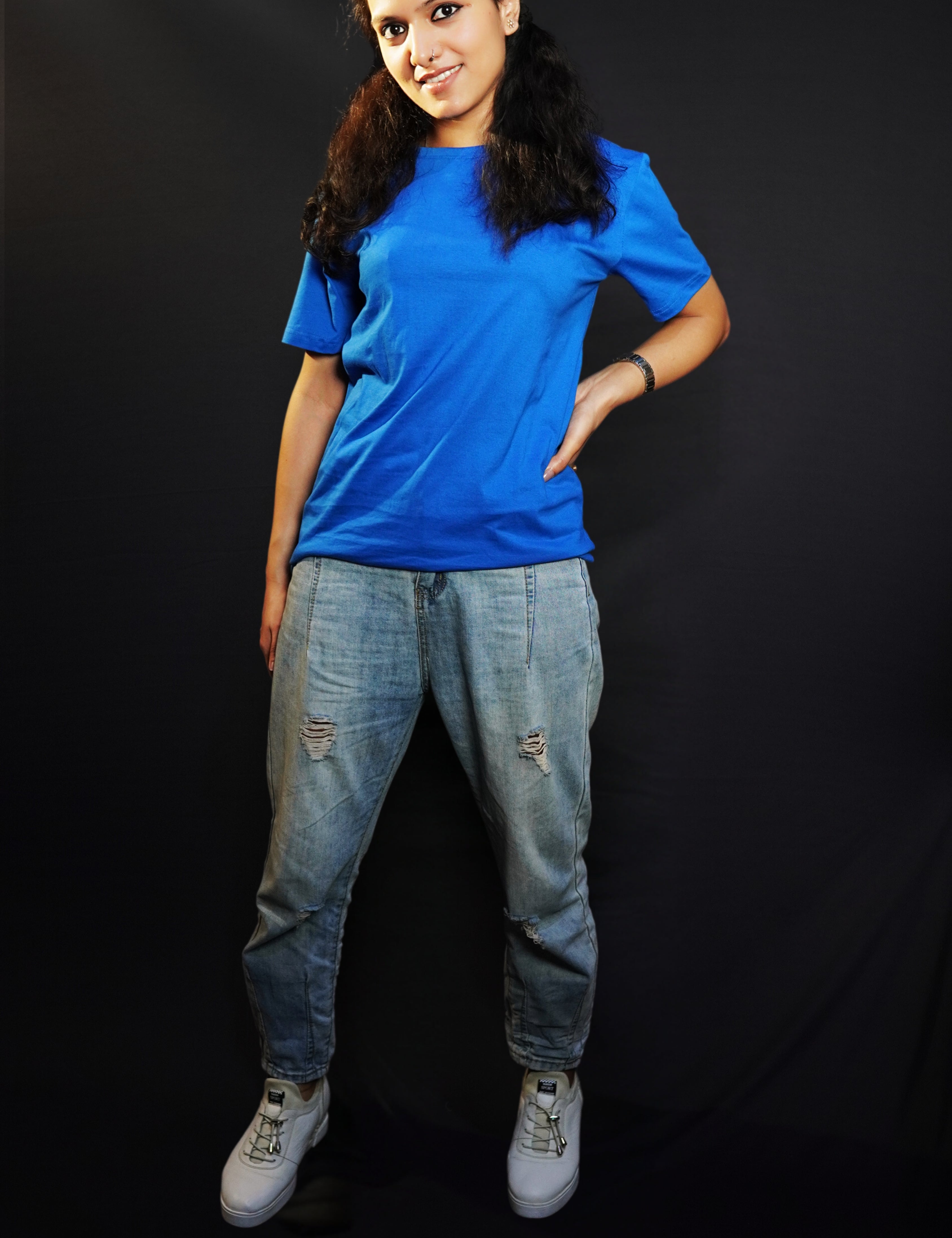 A woman wearing a cotton short sleeved round neck long t-shirt, posing with her hand on her waist and another hanging behind her, highlighting a modish slouchy fit-Muselot