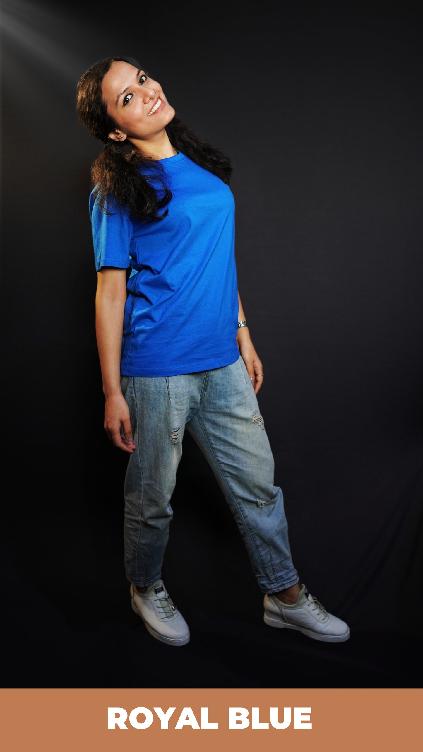 A woman wearing men's plain cotton stretchable royal blue t-shirt, posing as she stands slightly backwards with her hands hanging on her sides, highlighting a relaxed everyday look-Muselot