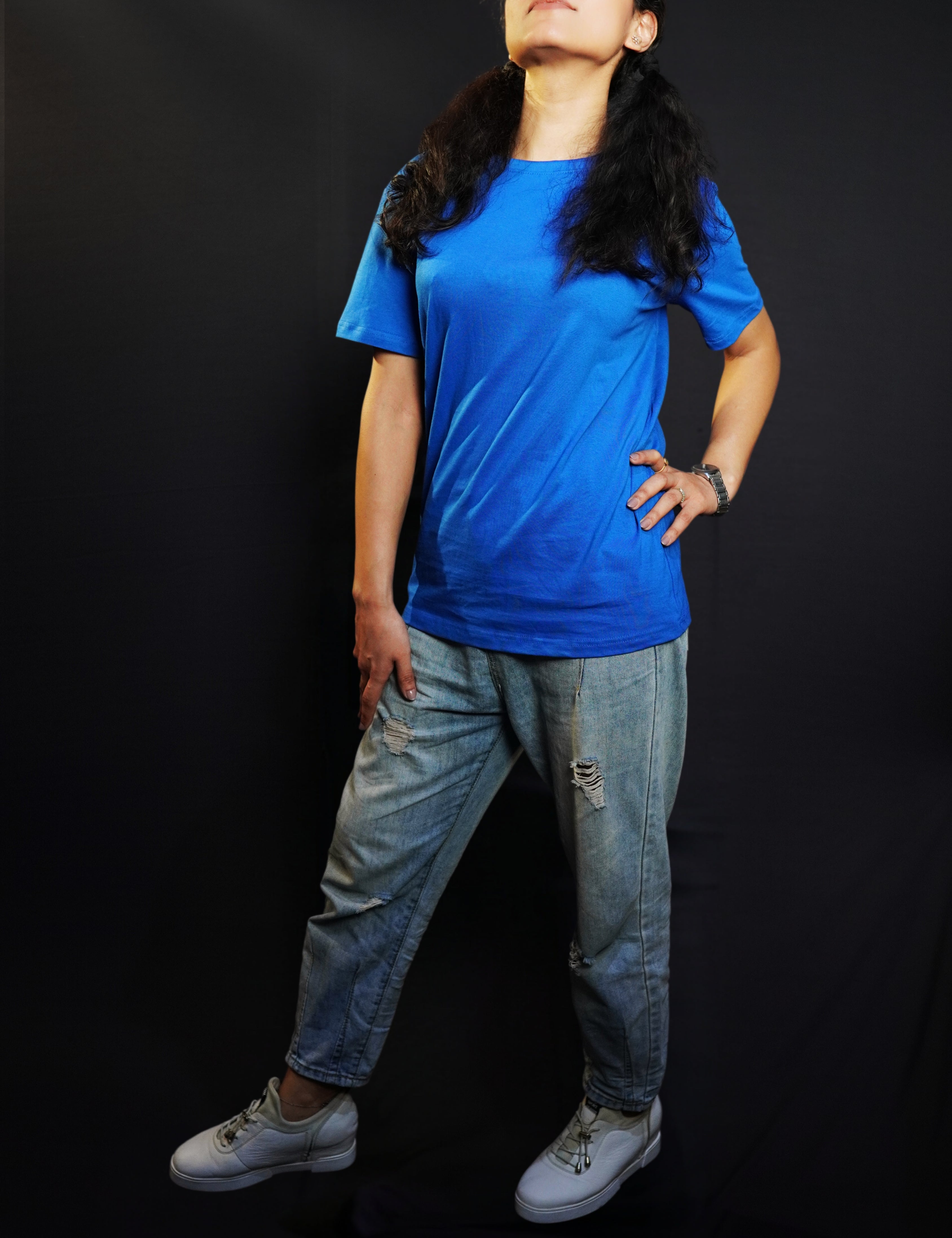 A woman with her chin high and hand on her waist and thigh, wearing a round neck quick drying summer cotton royal blue t-shirt, highlighting a trendy informal fit-Muselot