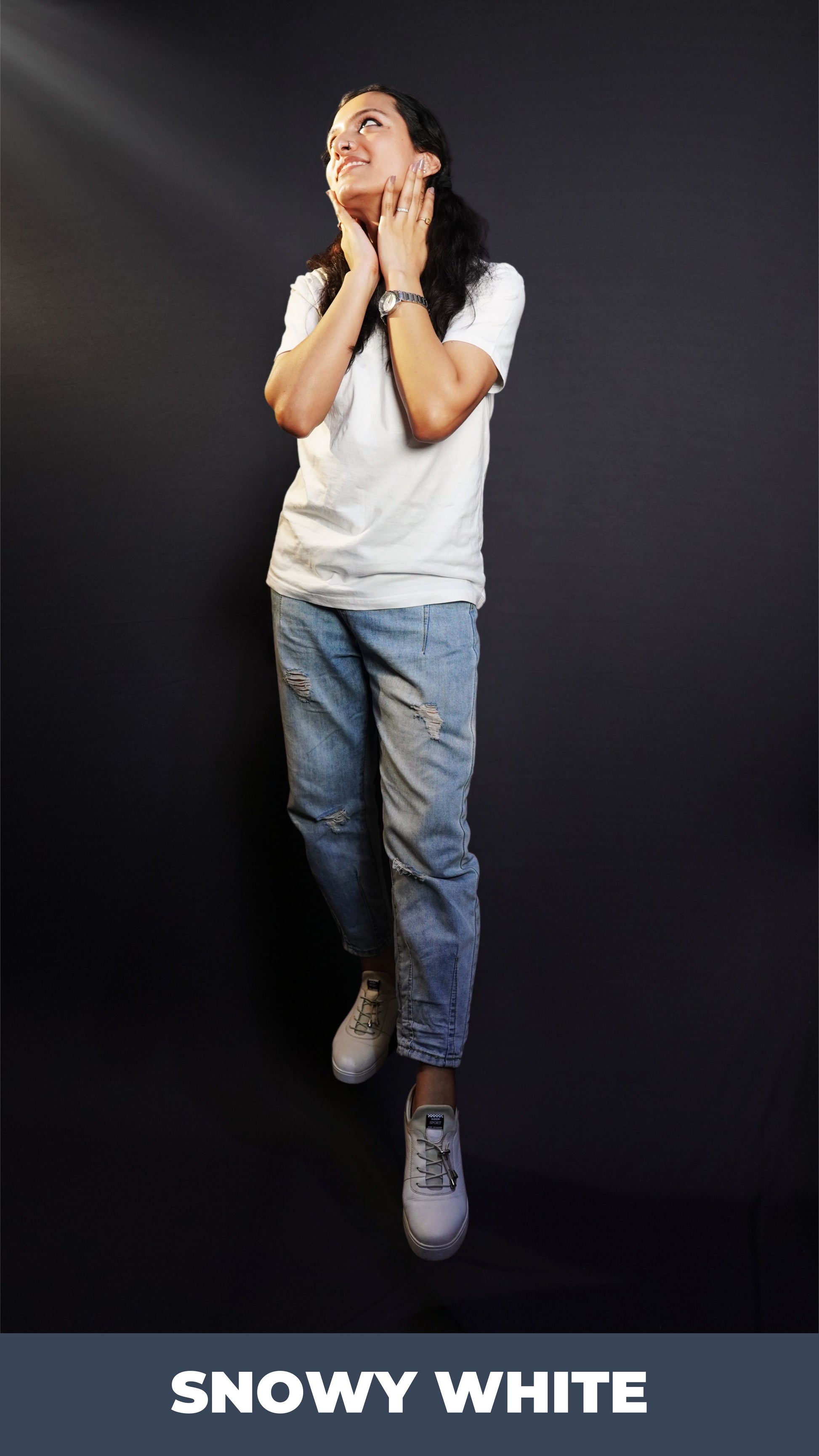 A stylish model posing with her hands on her neck, smiling happily, wearing a unisex plain snowy white round neck t-shirt, showcasing an elegant modern look-Muselot