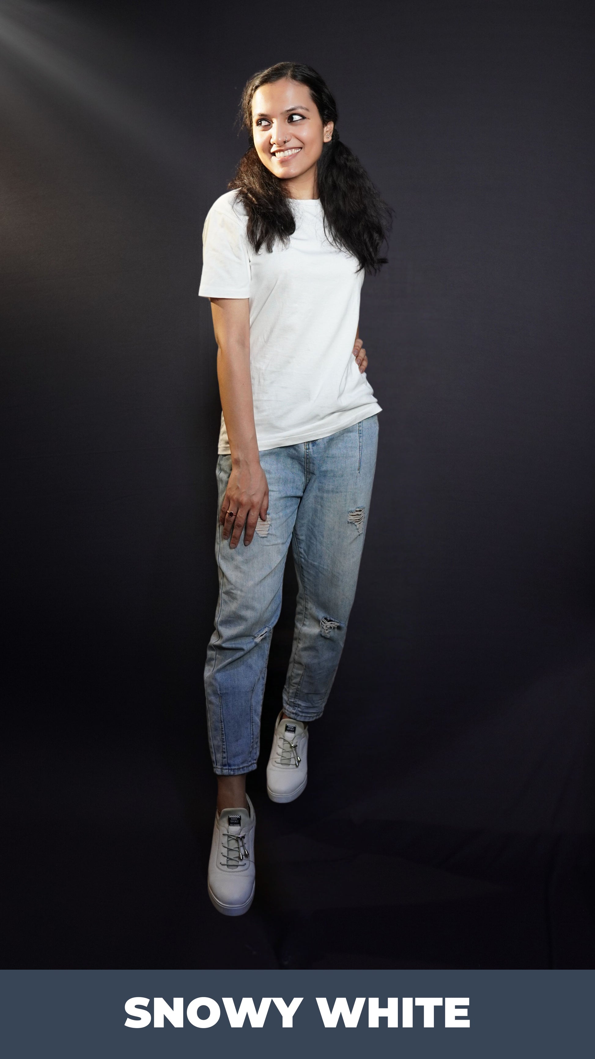 A woman smiling brightly posing with her hand on her thigh, standing sideway with another hand on her waist, wearing a women's summer short sleeved snowy white t-shirt, showcasing a comfortable snug fit-Muselot