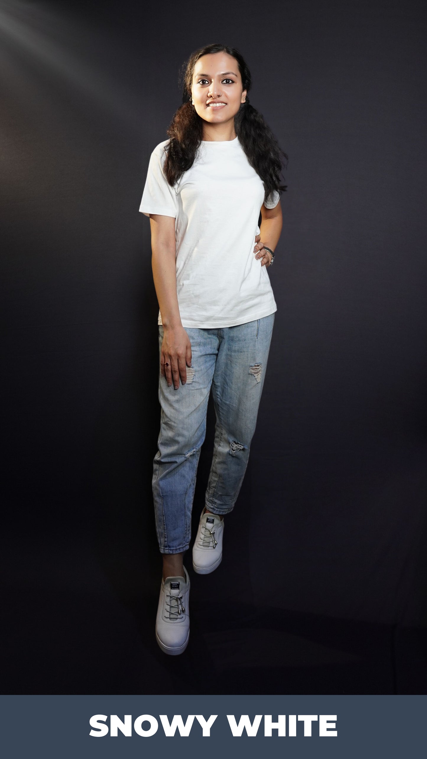 A stylish model posing with her hand on her waist and another on her thigh looking directly at the camera, wearing an adult's summer long length stretchable snowy white t-shirt, showcasing an elegant informal look-Muselot