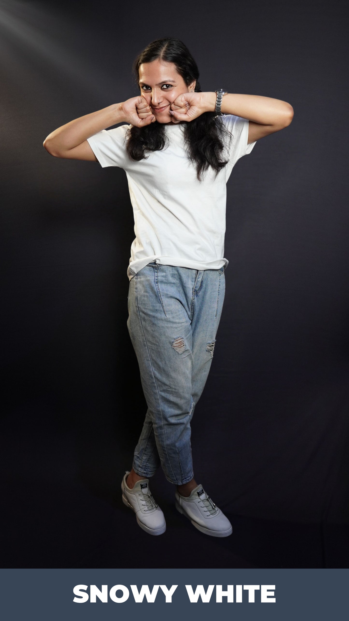 A woman happily posing with her fists on her cheeks and a sweet smile on her lips, wearing a snowy white plain long length quick drying t-shirt, highlighting a relaxed cozy fit-Muselot