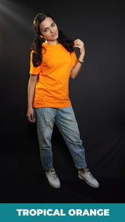 A woman wearing a plain round neck unisex tropical orange t-shirt, posing with her hand gently grazing her hair, smiling with her eyes, showcasing a stylish pretty look-Muselot