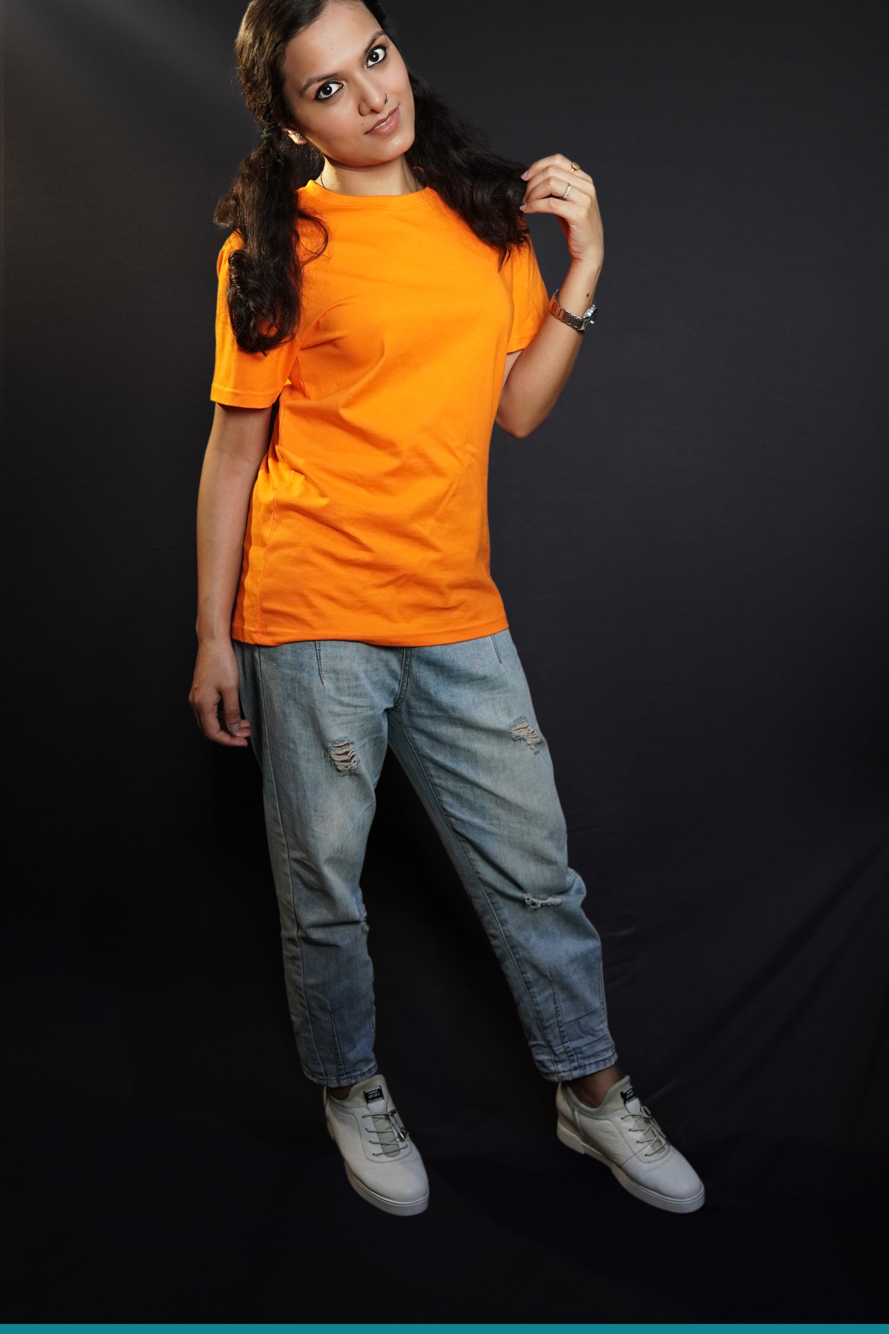 A woman wearing a plain round neck unisex tropical orange t-shirt, posing with her hand gently grazing her hair, smiling with her eyes, showcasing a stylish pretty look-Muselot