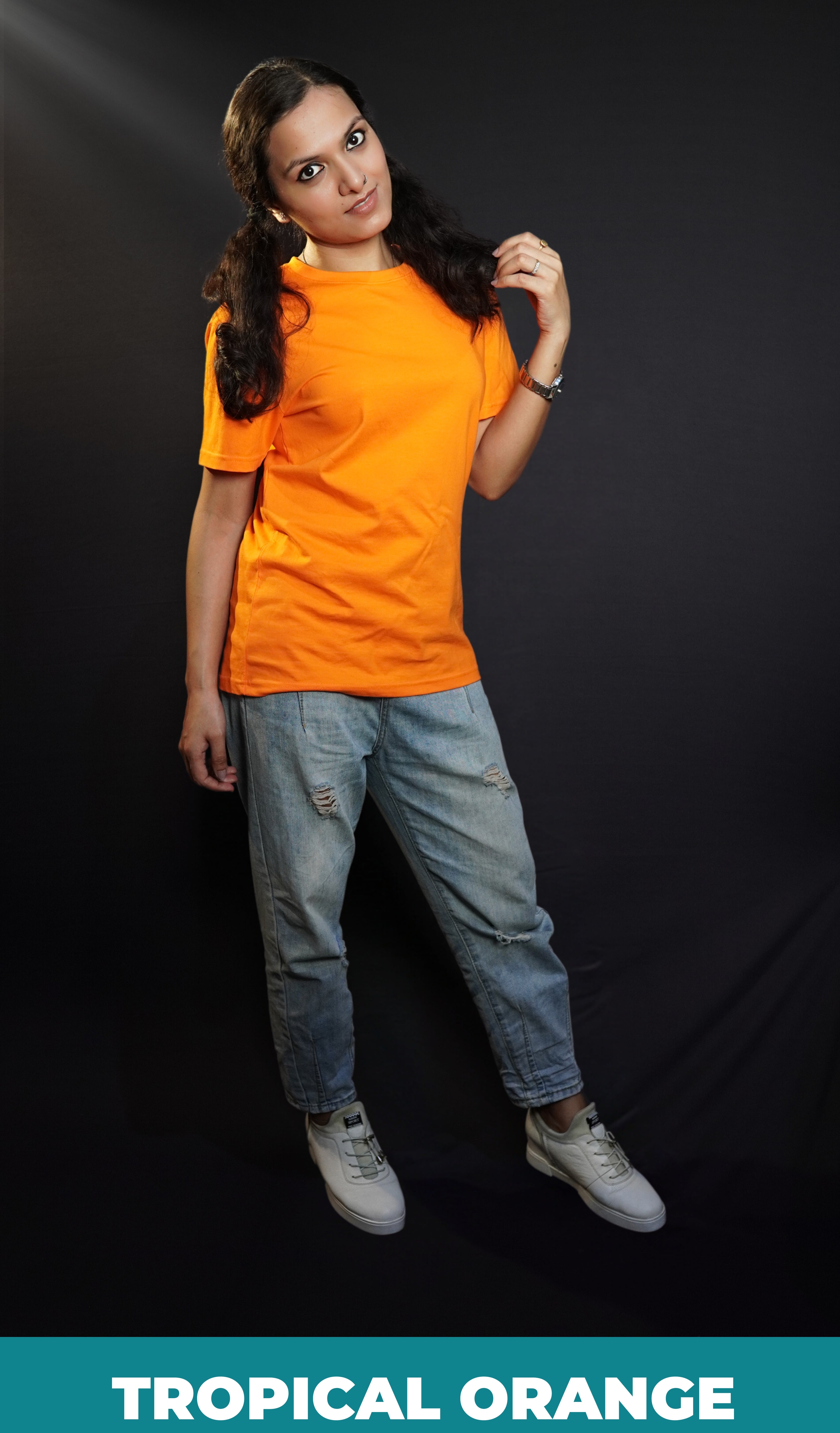 A woman wearing a plain round neck unisex tropical orange t-shirt, posing with her hand gently grazing her hair, smiling with her eyes, showcasing a stylish pretty look-Muselot