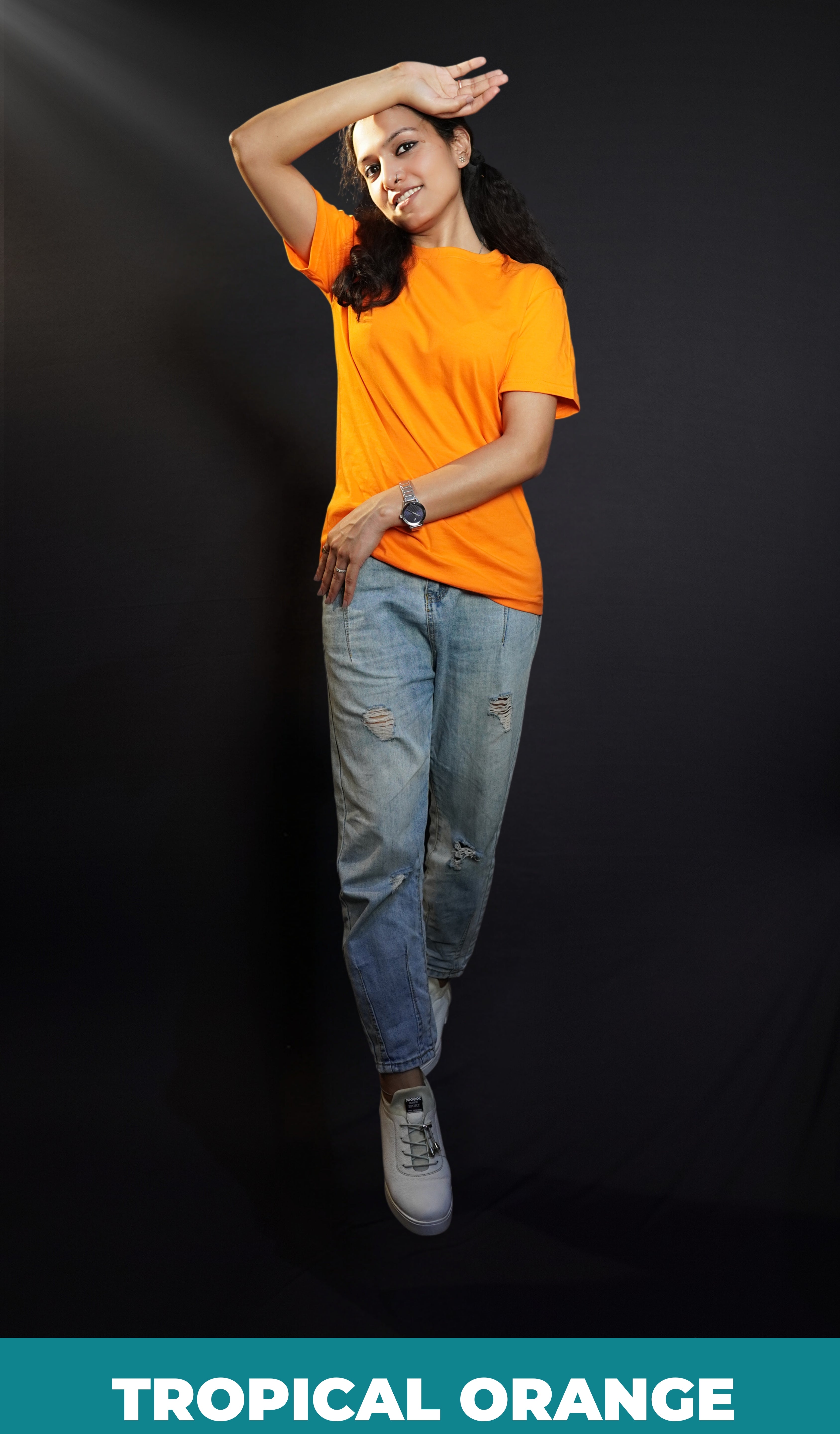 A stylish model posing with her hand upon her forehead and other gently hugging her sideways, wearing a men's plus size long length plain orange t-shirt, highlighting a stylish in vogue look-Muselot