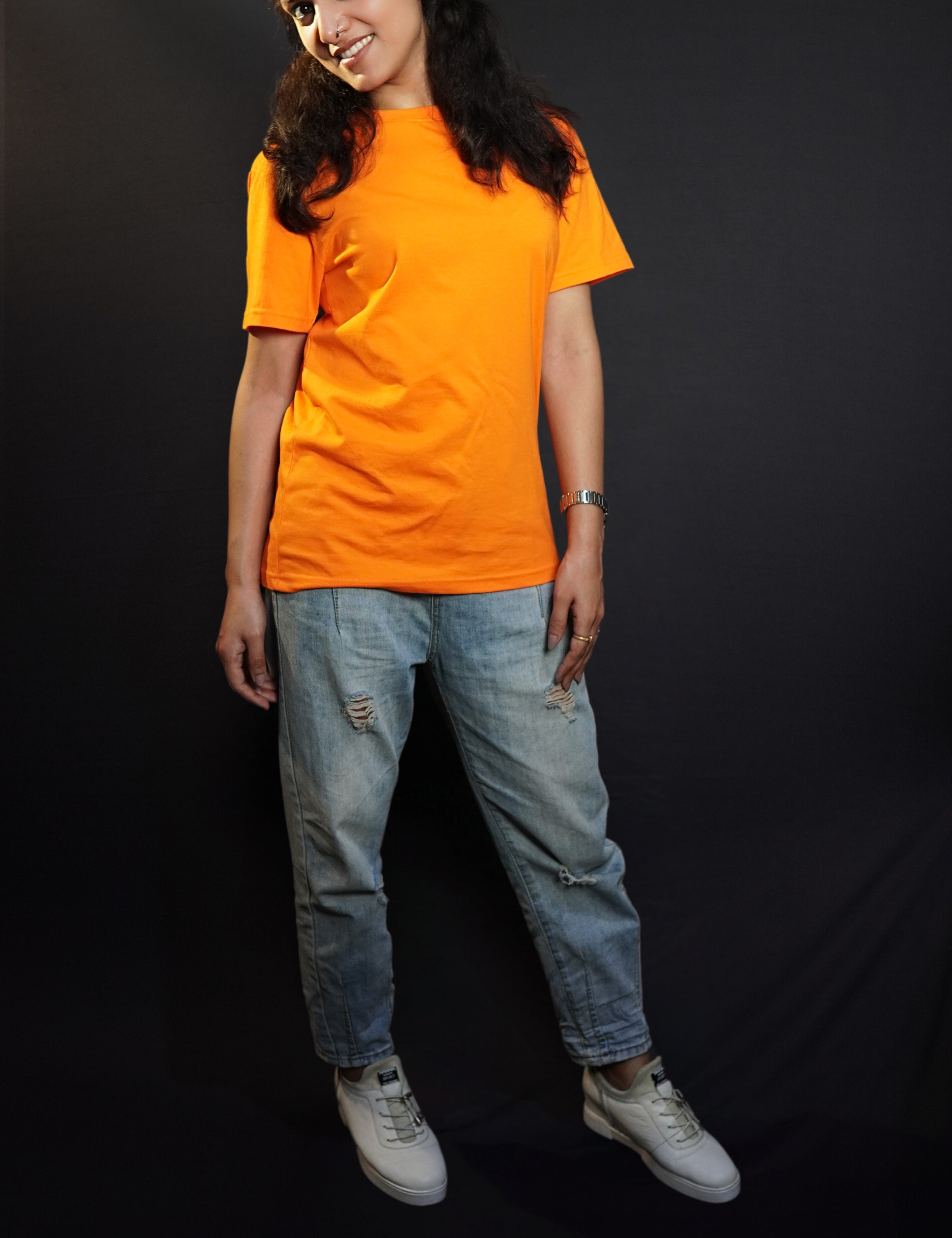 A woman smiling brightly with her head bending sideways, wearing an adult's plus size stretchable tropical orange t-shirt, showcasing a trendy baggy fit-Muselot