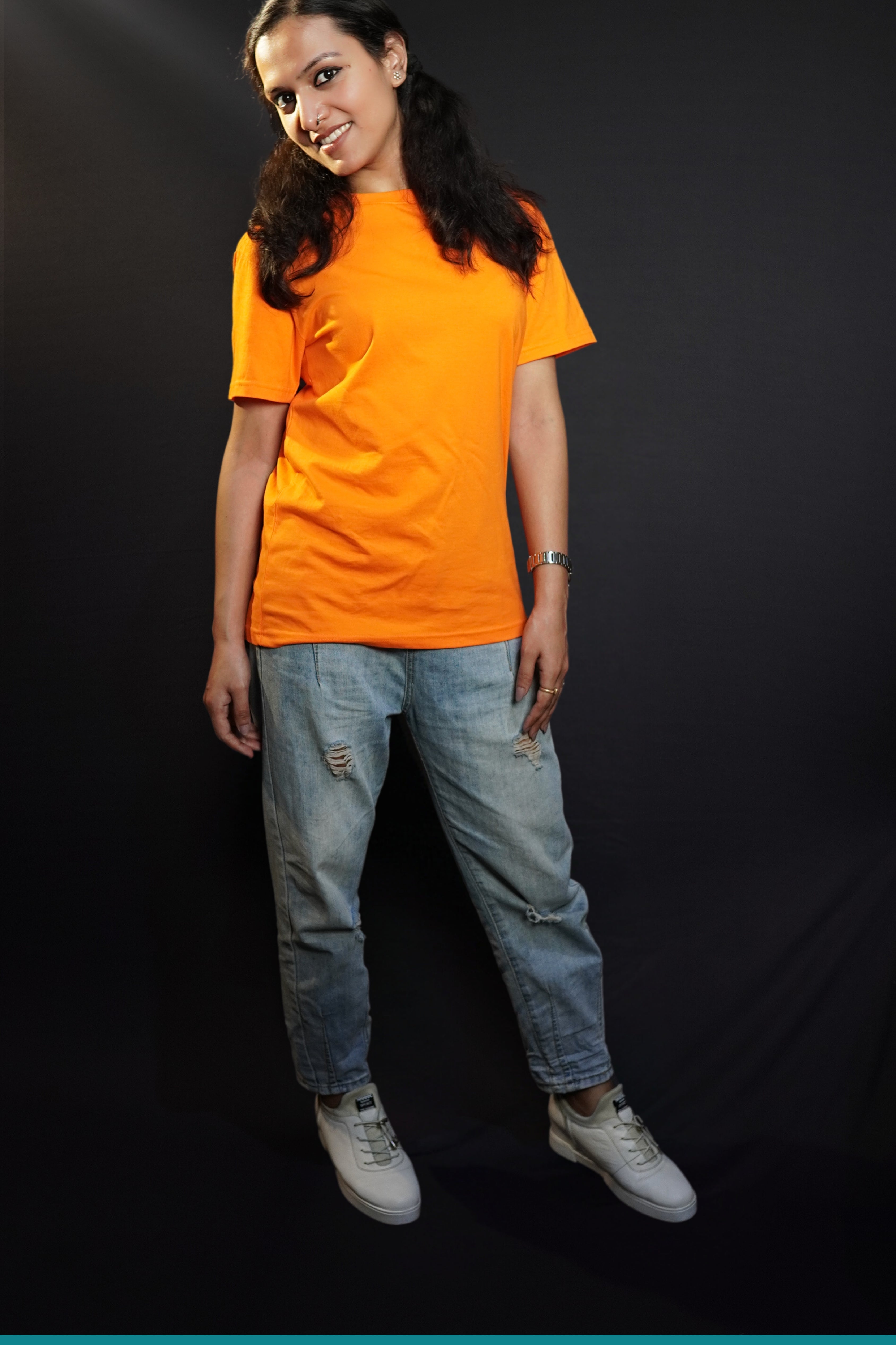 A woman smiling brightly with her head bending sideways, wearing an adult's plus size stretchable tropical orange t-shirt, showcasing a trendy baggy fit-Muselot